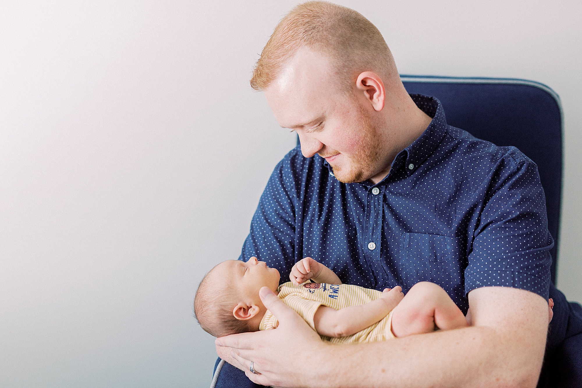 dad looks down at son during lifestyle newborn session