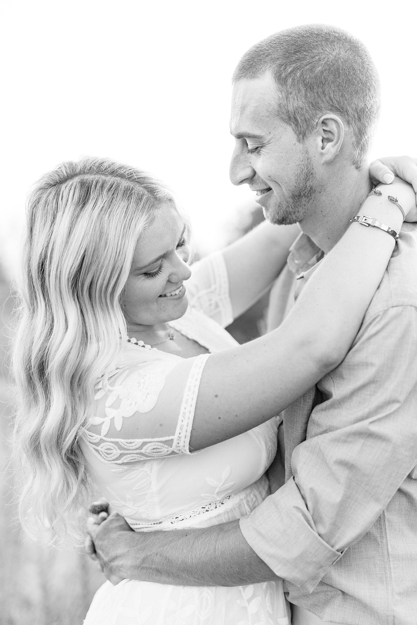 groom looks down at bride making her laugh during Mount Airy engagement session