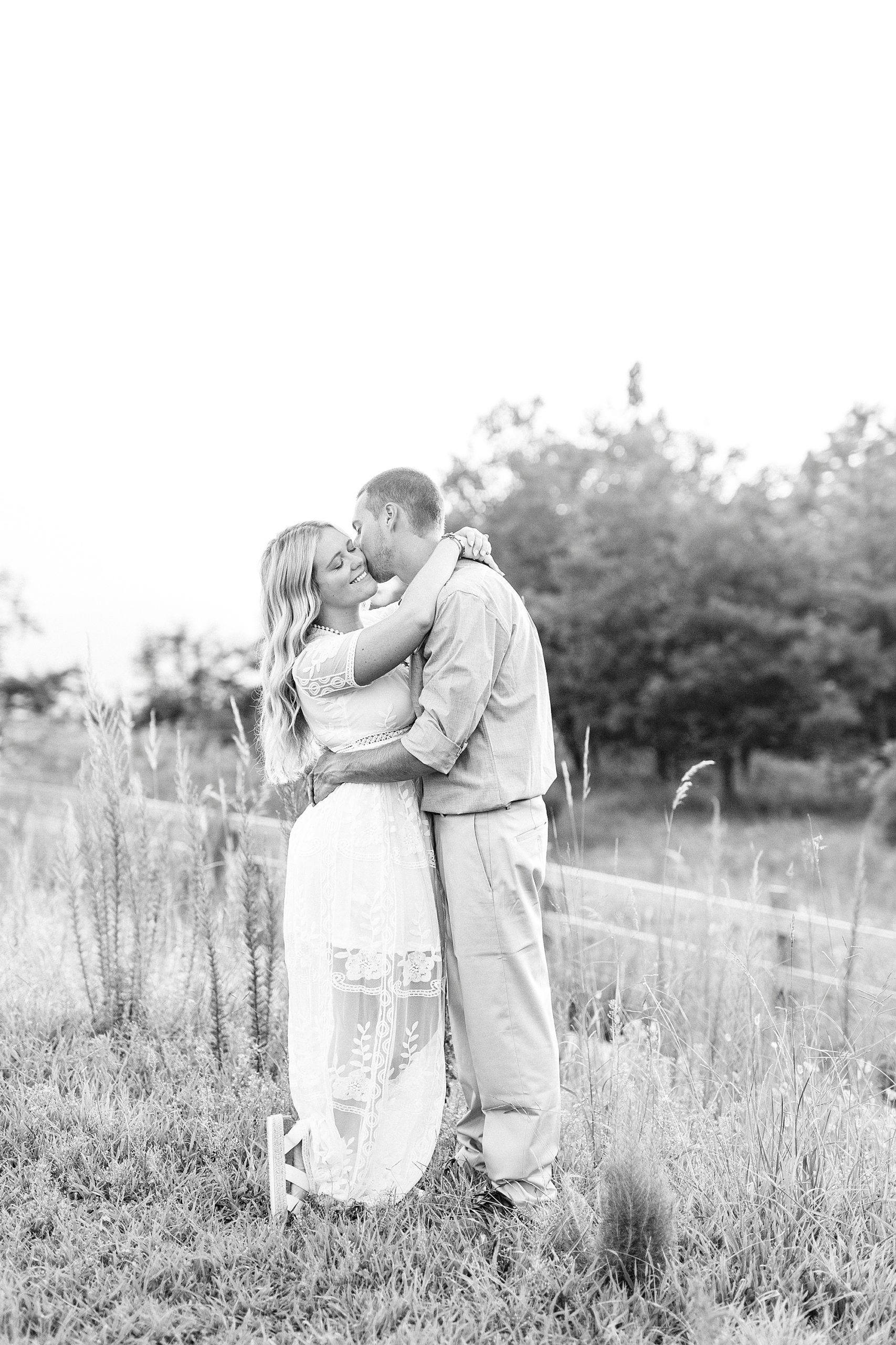 bride and groom pose in grassy area on Pilot Mountain