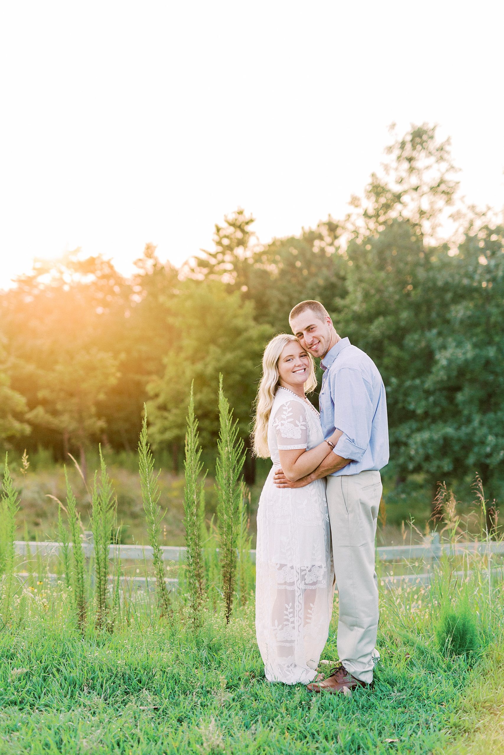 bride and groom hug in grassy area during Mount Airy engagement session