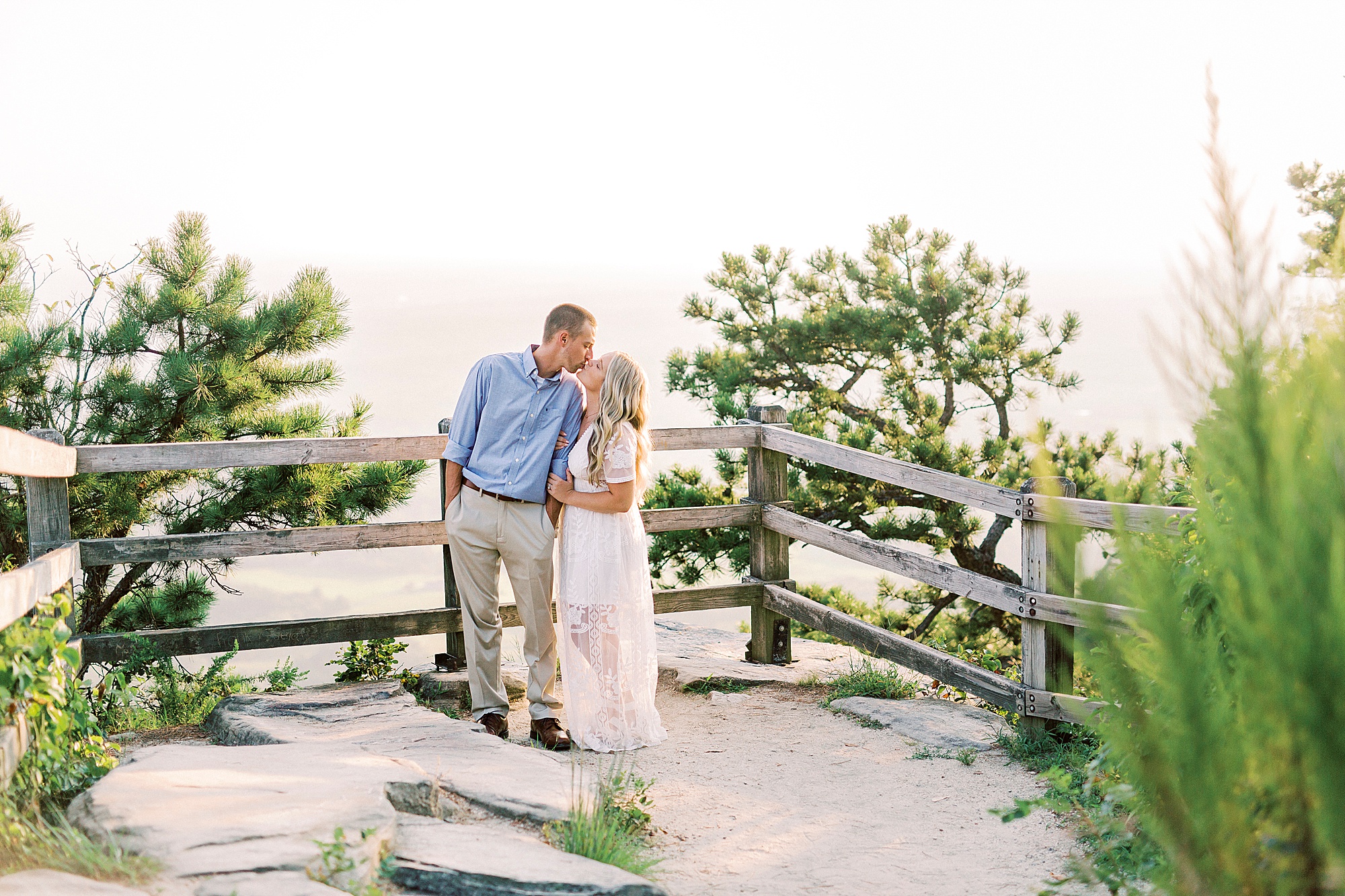 engaged couple stands on top of Pilot Mountain