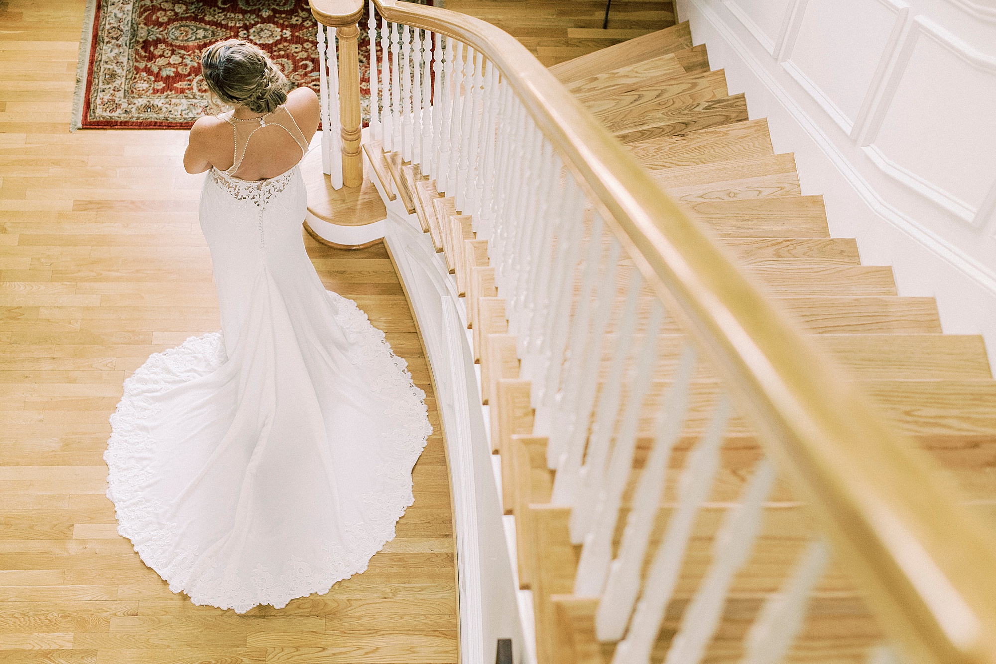 bride poses by staircase in childhood home
