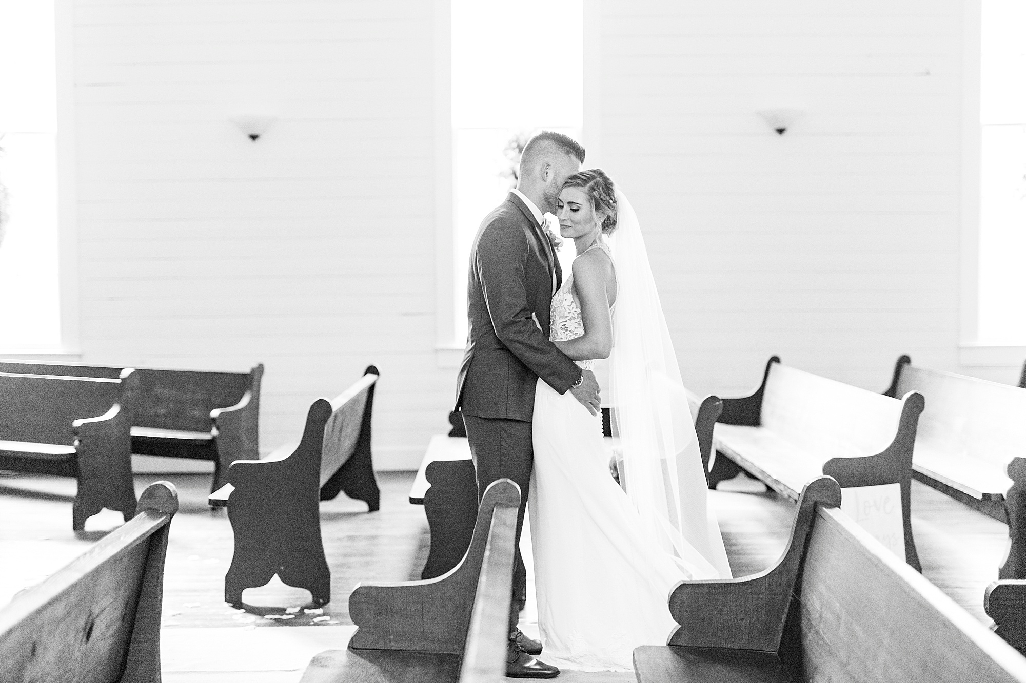 bride and groom hug in pews after traditional church wedding in Winston-Salem NC