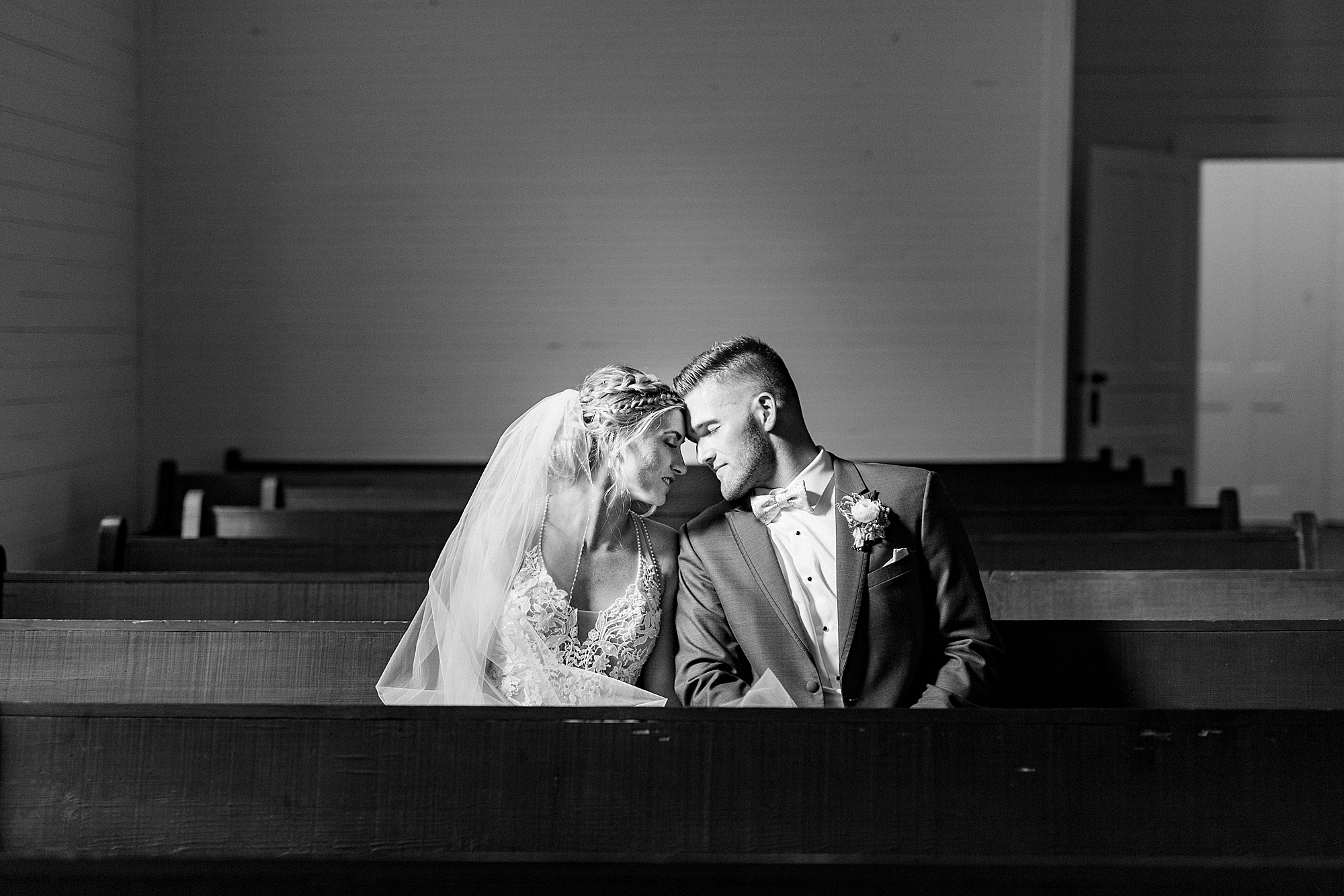 newlyweds sit on church bench