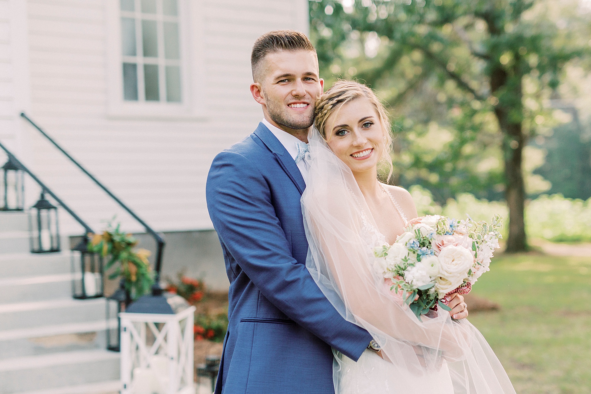 bride and groom hug outside white church