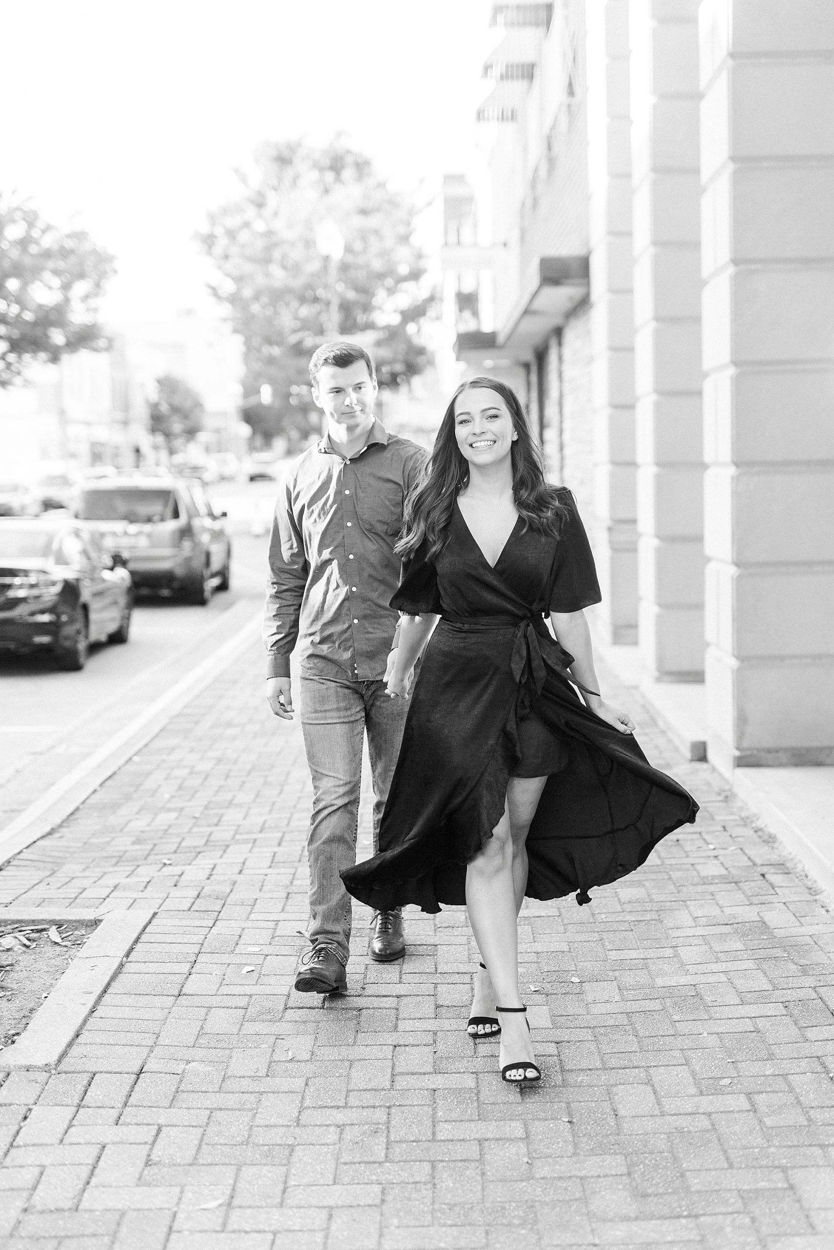 bride and groom hold hands walking down sidewalk in Downtown Concord