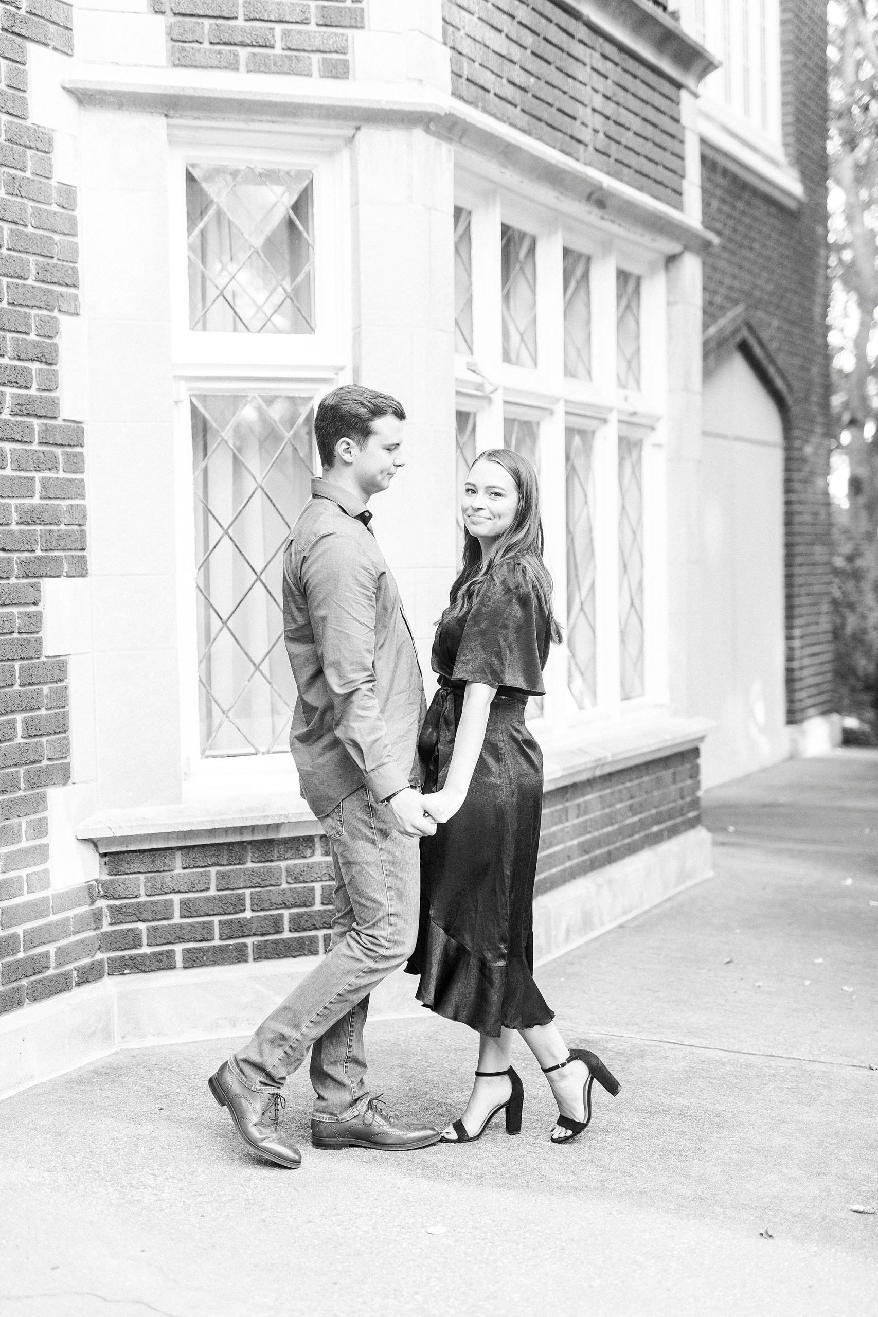 couple holds hands by storefront in Downtown Concord