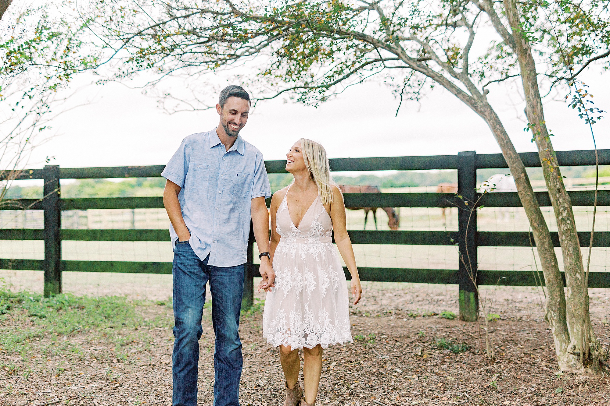 couple holds hands walking through Hodges Family Farm