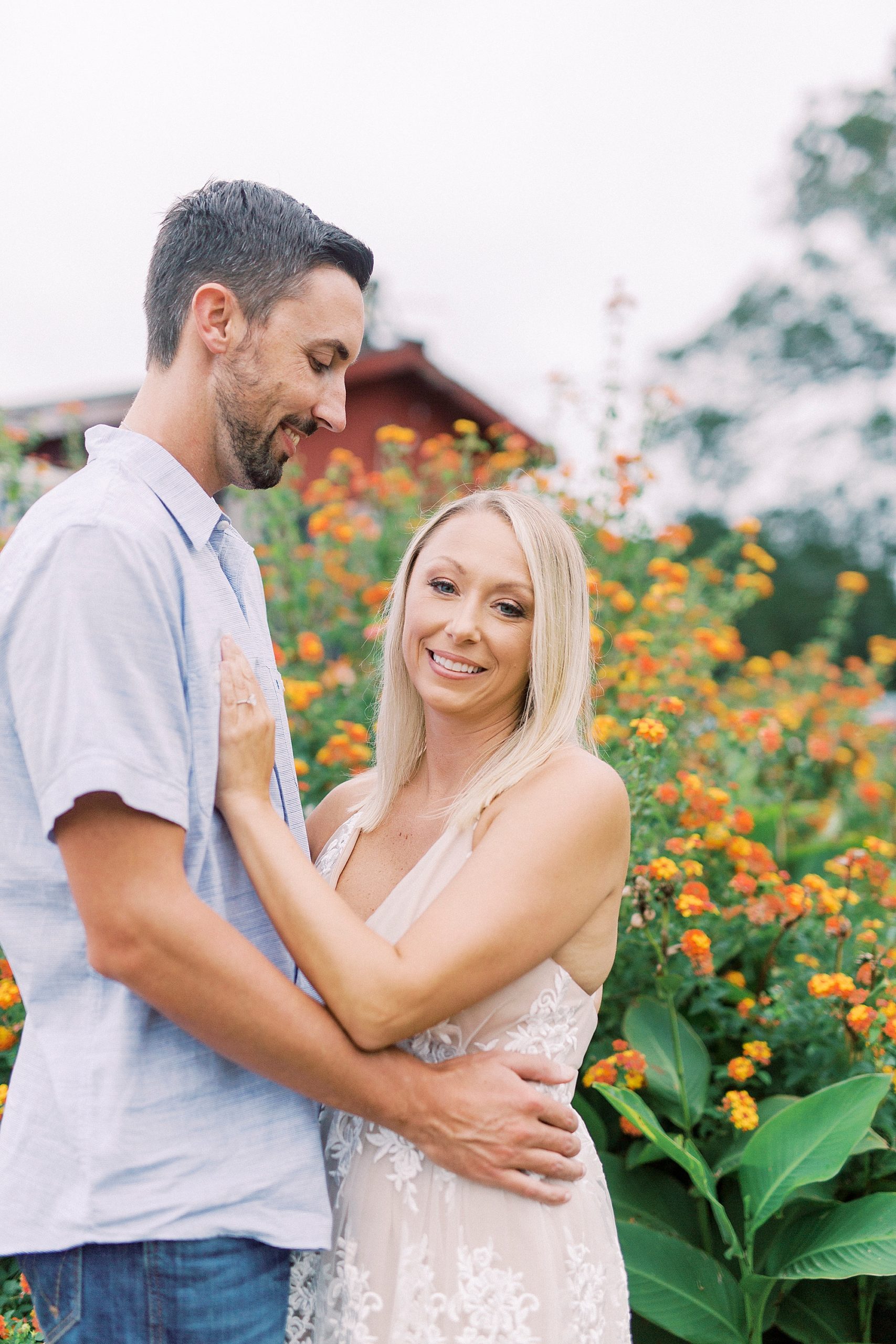 bride and groom pose by orange flowers at Hodges Family Farm