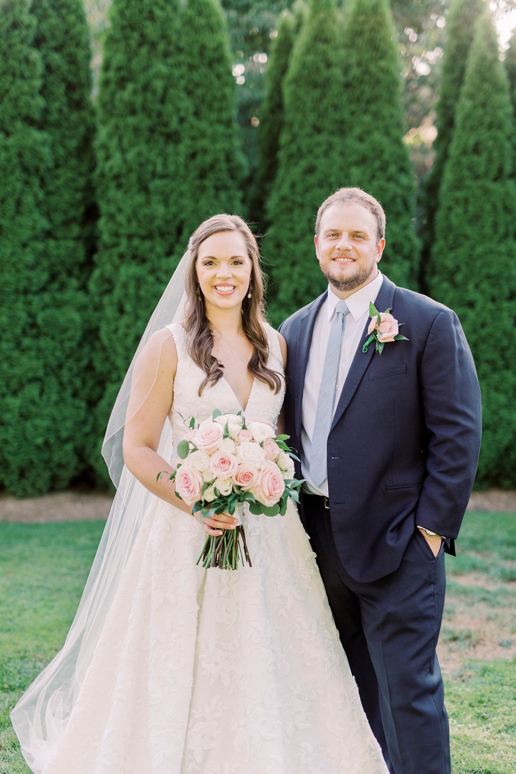 newlyweds stand together by trees in Blowing Rock NC