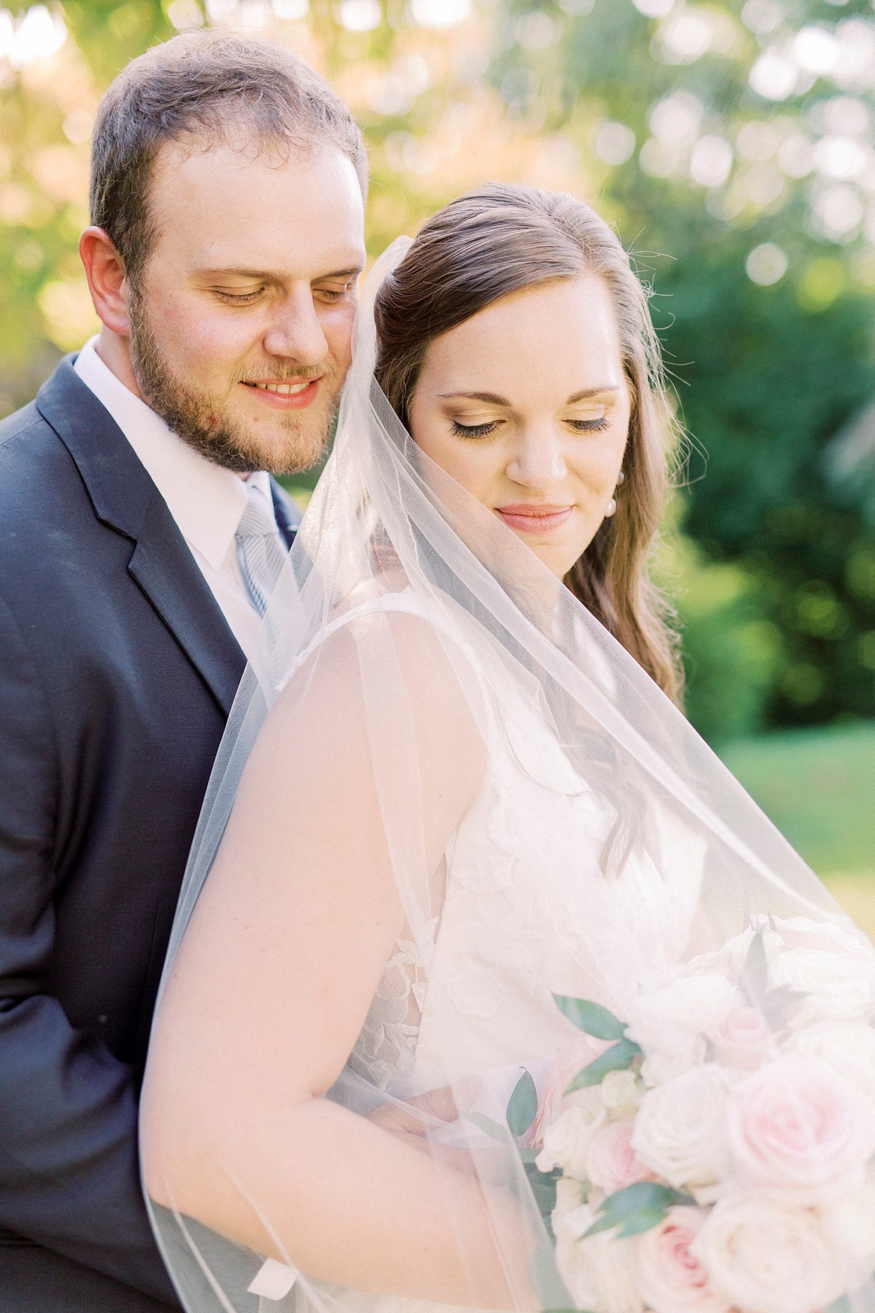 bride and groom stand together looking over bride's shoulder