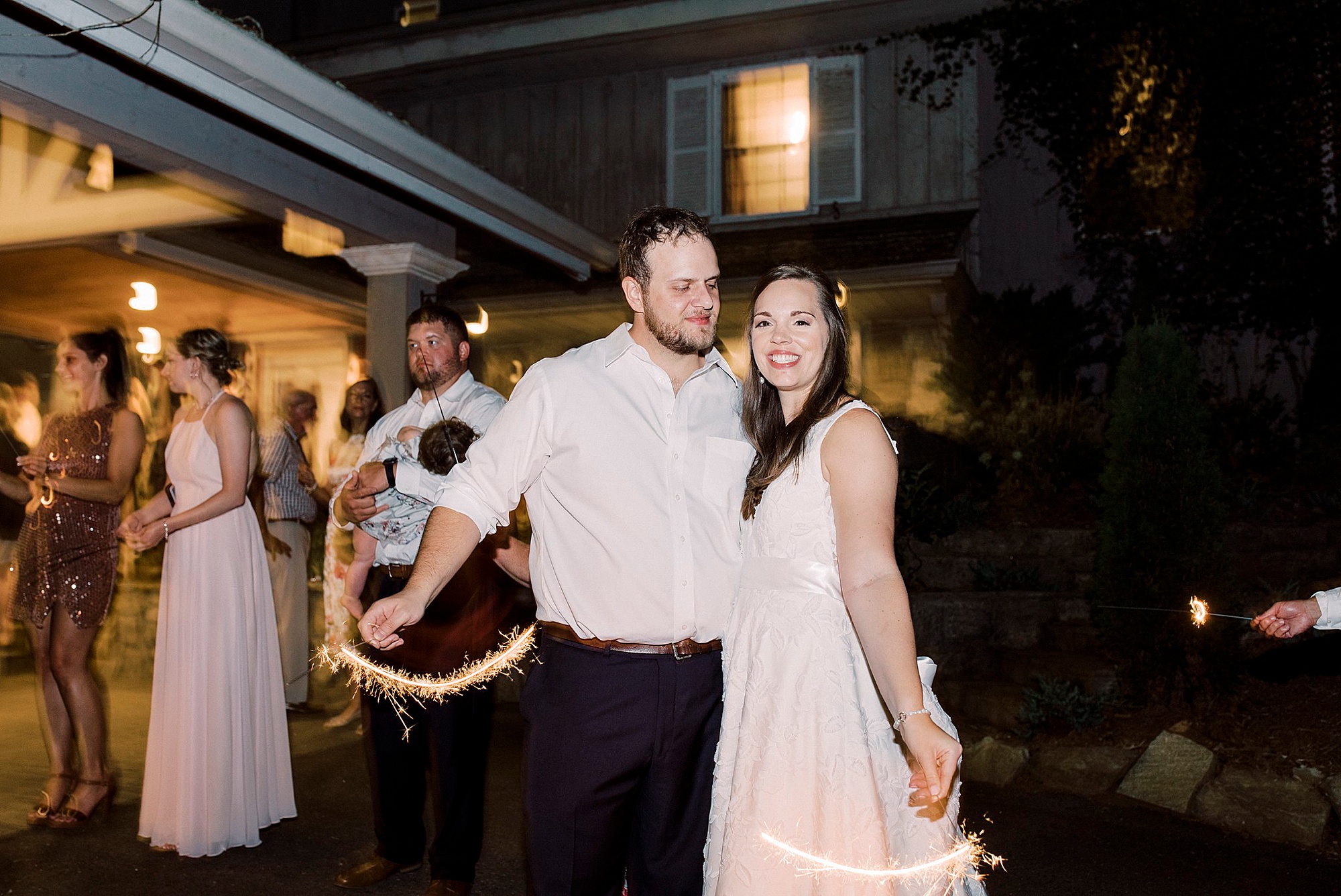 bride and groom move sparklers during exit