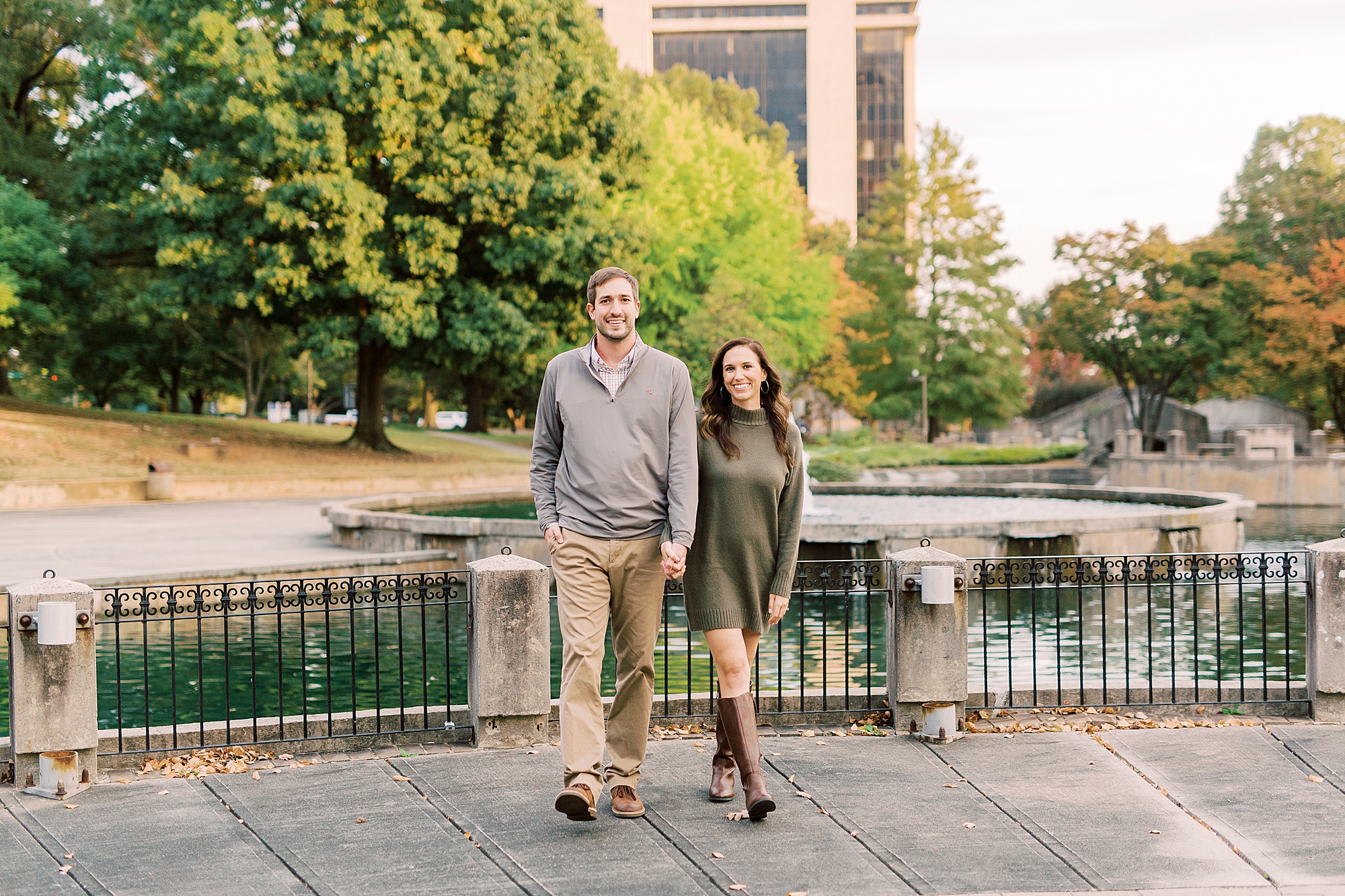 engaged couple walks by fountain during Marshall Park engagement session