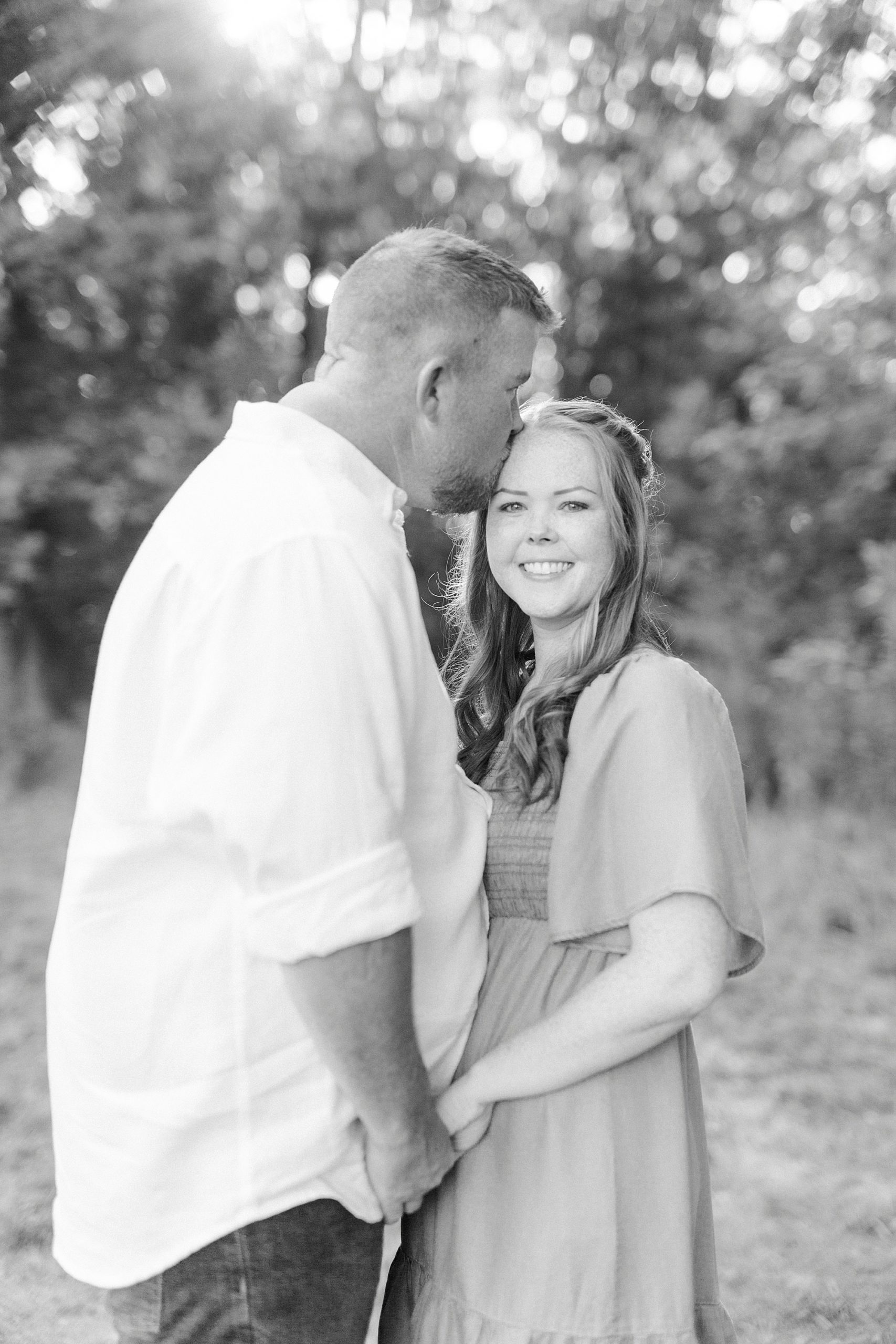 groom kisses bride's forehead during Sunset Farm engagement session
