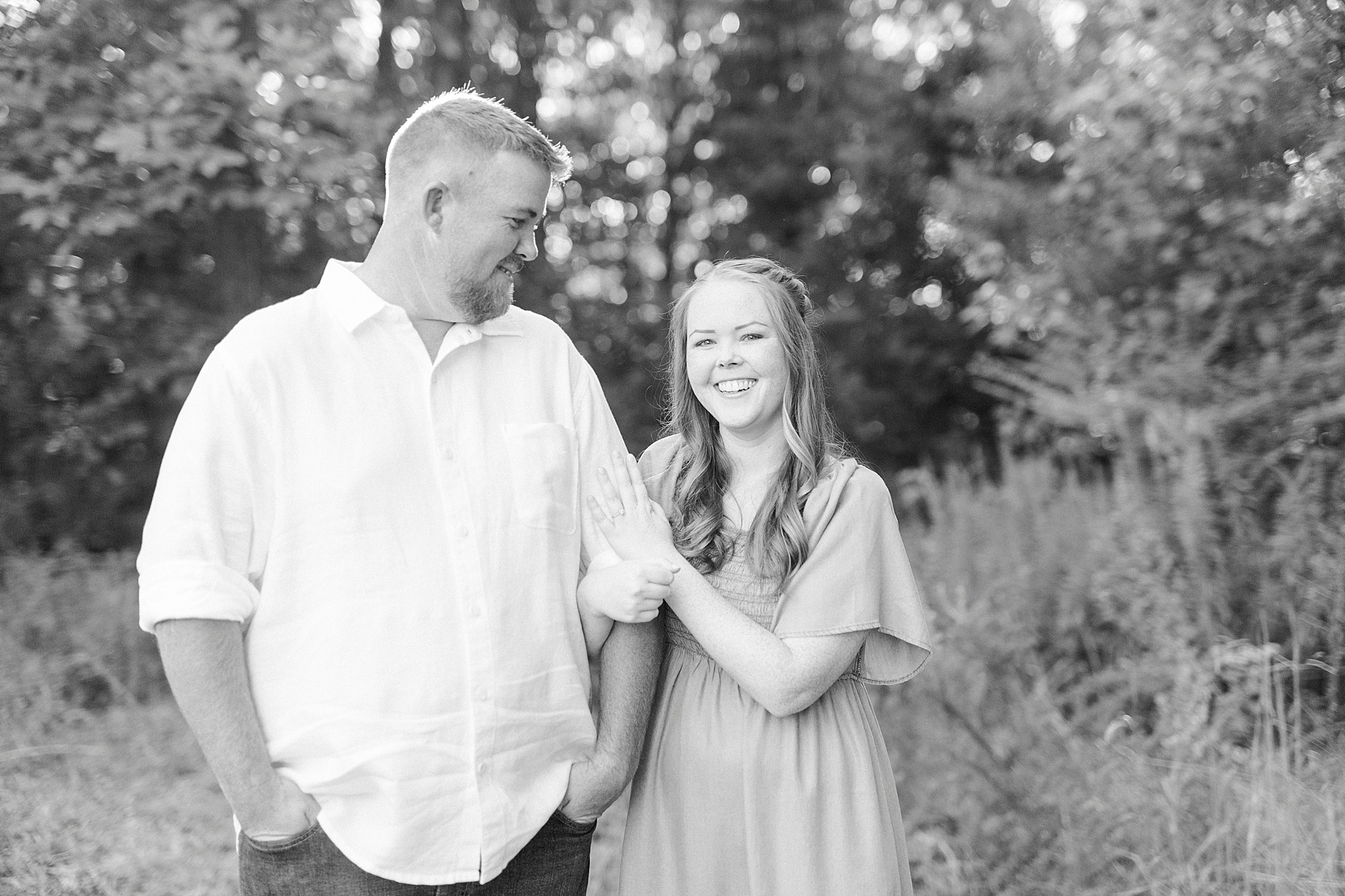 engaged couple stands in tress during Charlotte NC engagement photos