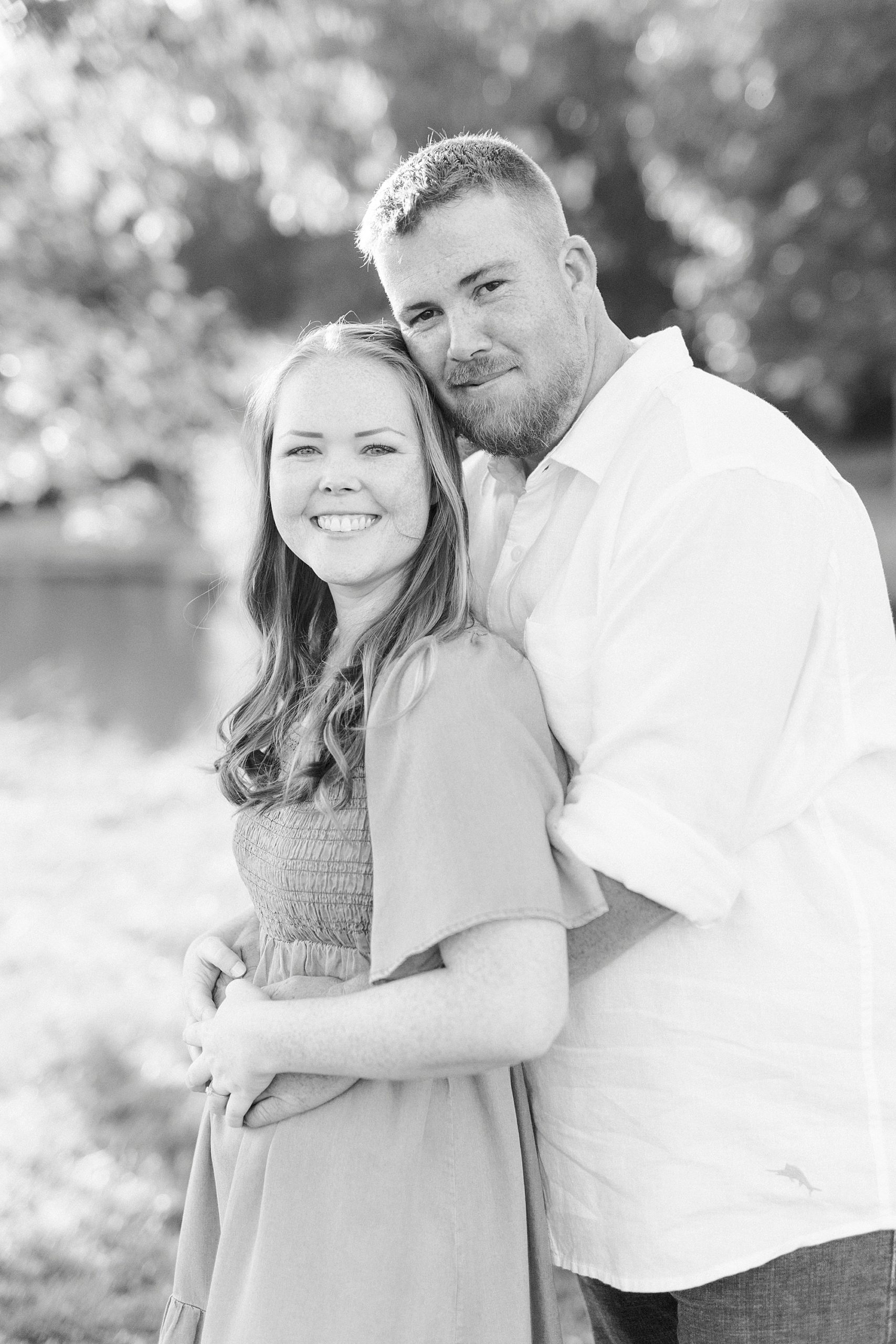 groom hugs bride during fall Sunset Farm engagement session