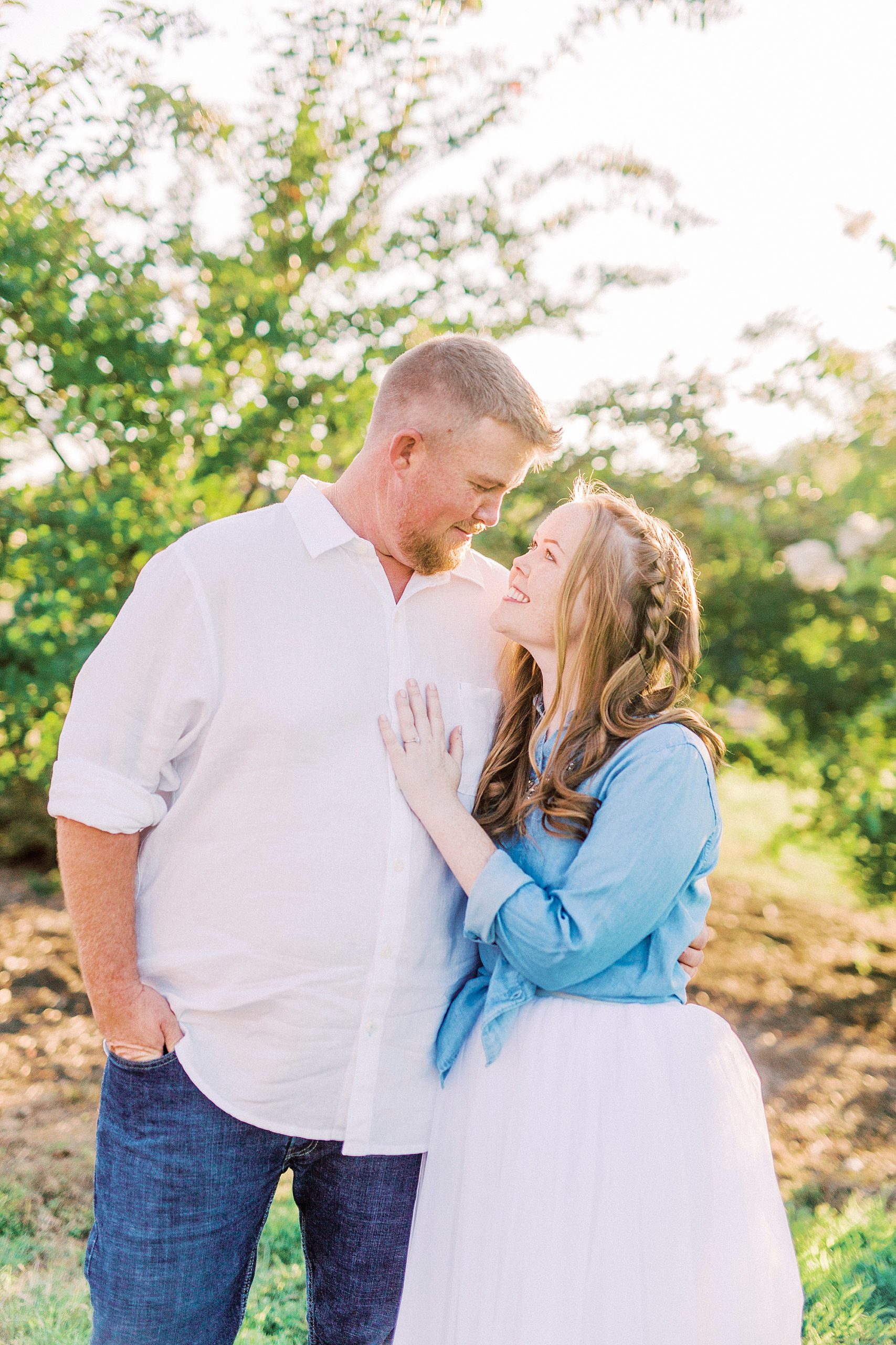 engaged couple hugs during Sunset Farm engagement session