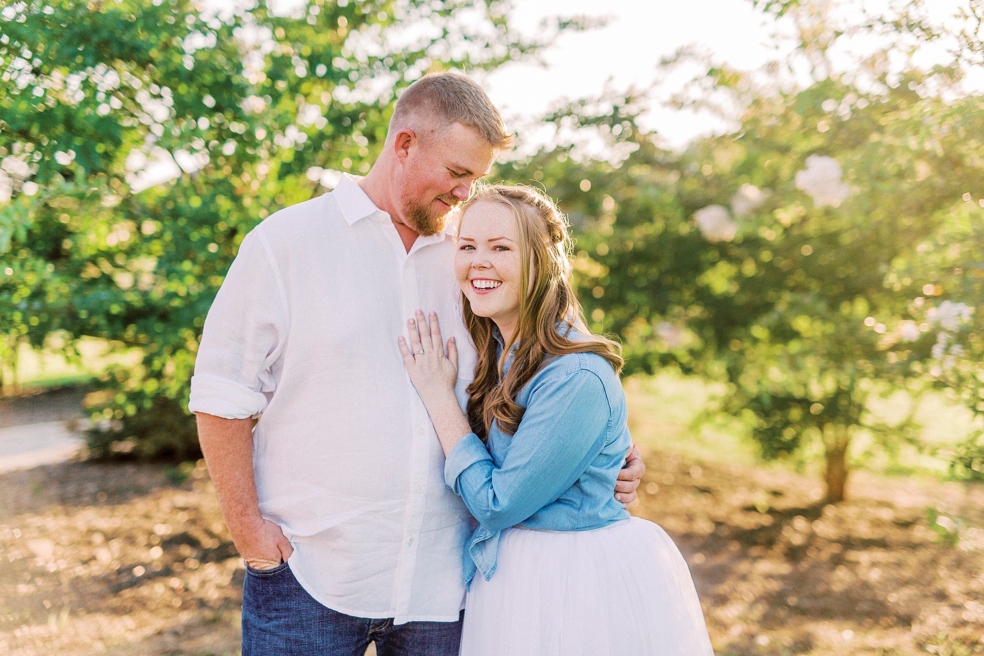 bride leans on groom laugh during NC engagement photos