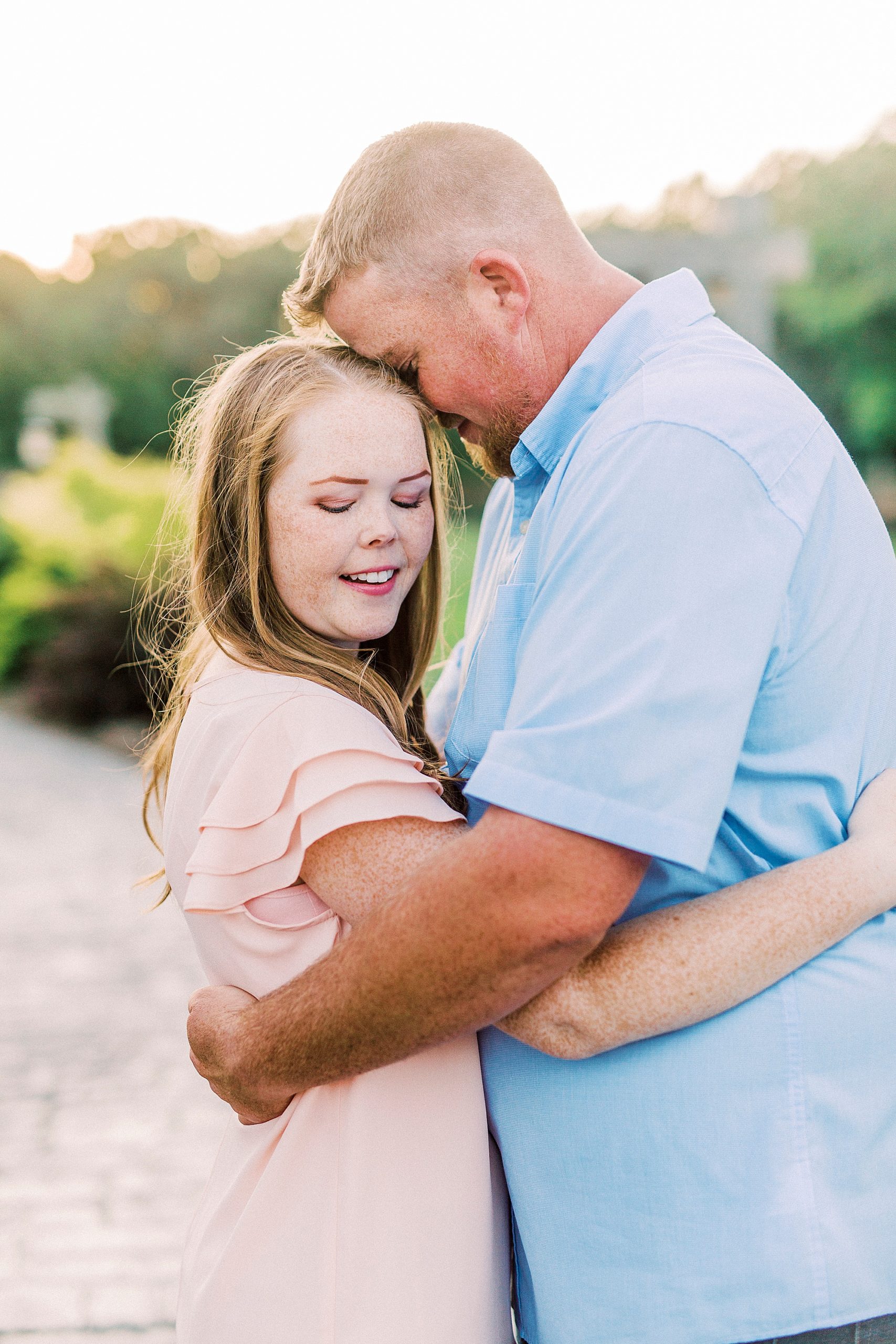 bride and groom hug at sunset during Sunset Farm engagement session
