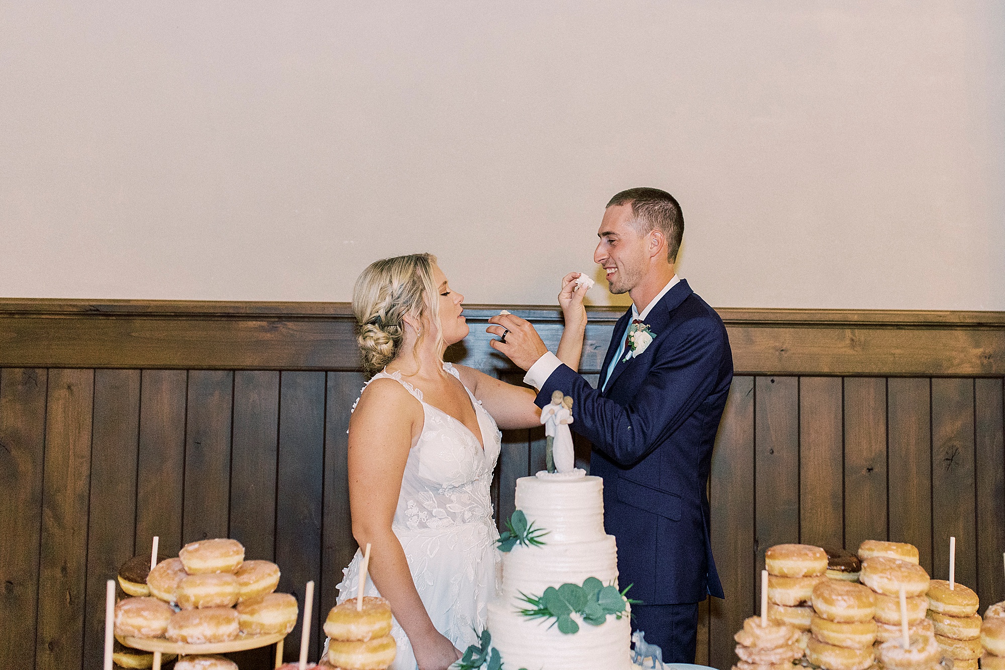 newlyweds feed each other cake during Greensboro NC wedding reception