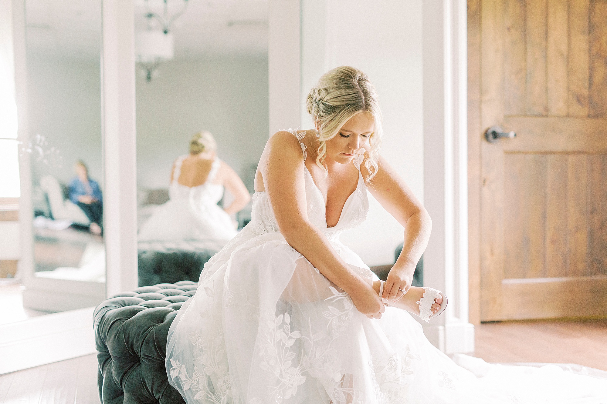 bride puts on shoes for Addison Farm wedding