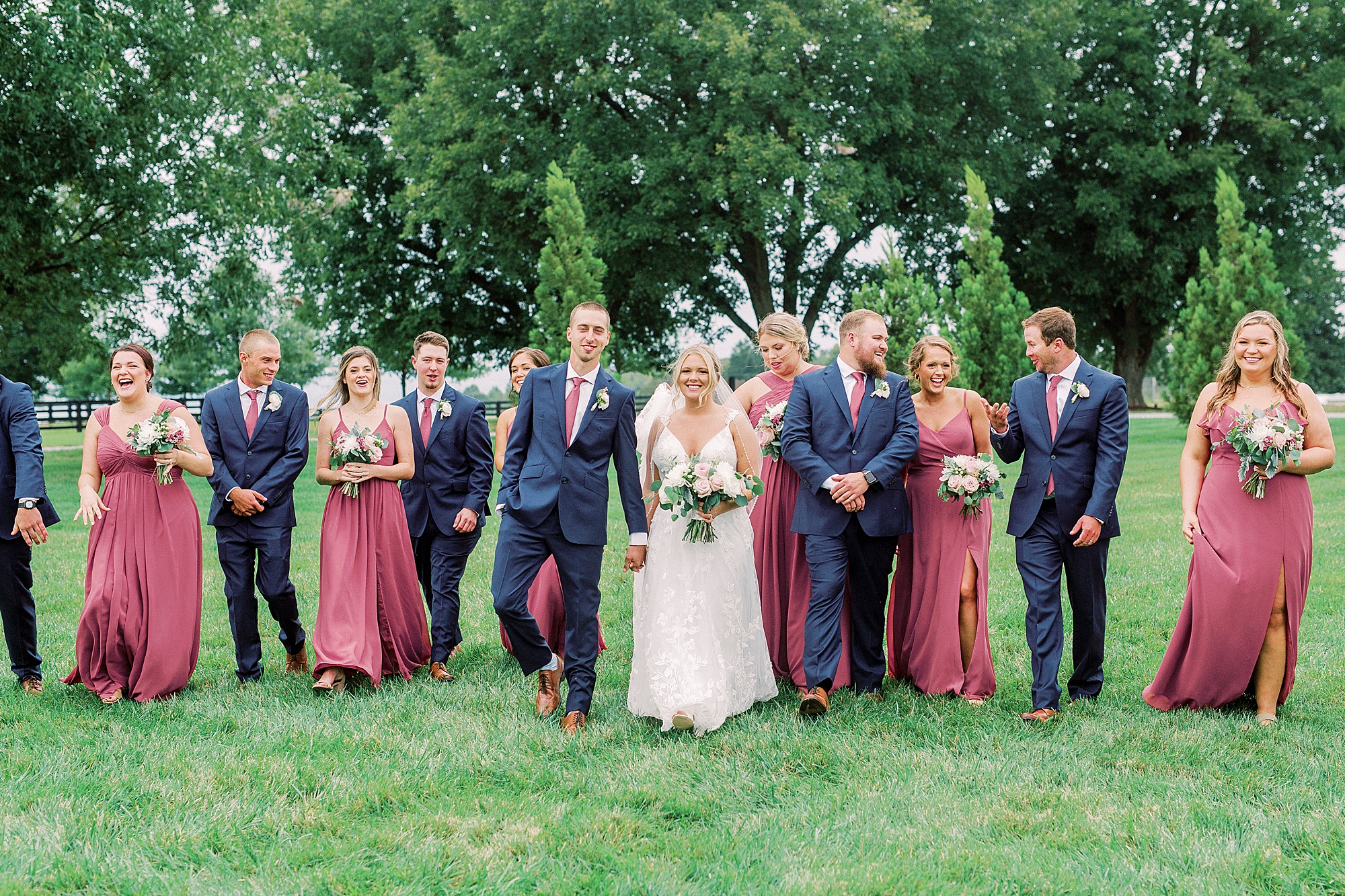 newlyweds walk with bridal party at Addison Farm
