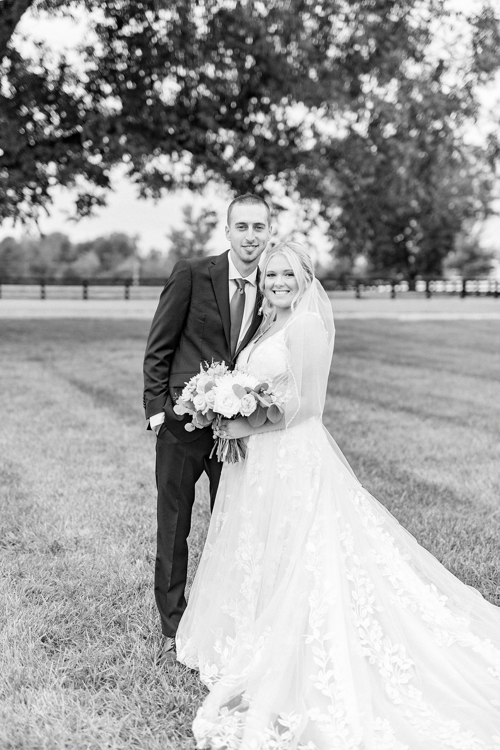newlyweds stand together during portraits on farm in Greensboro NC