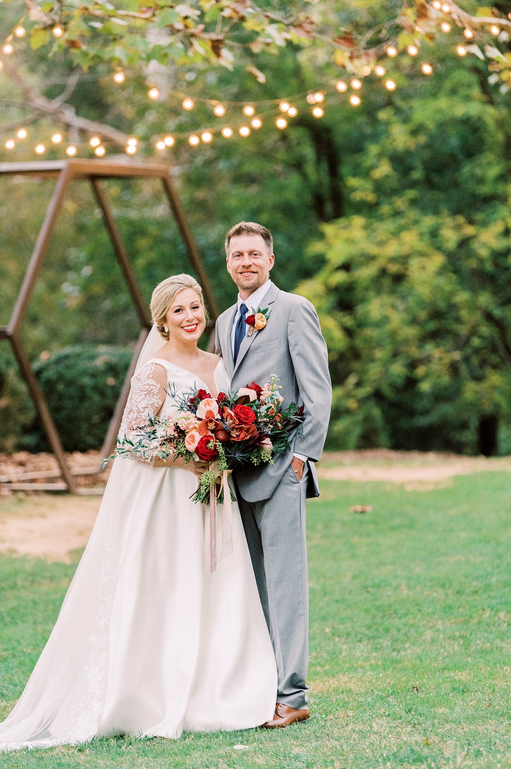 newlyweds stand together under twinkling lights at Vesuvius Vineyards