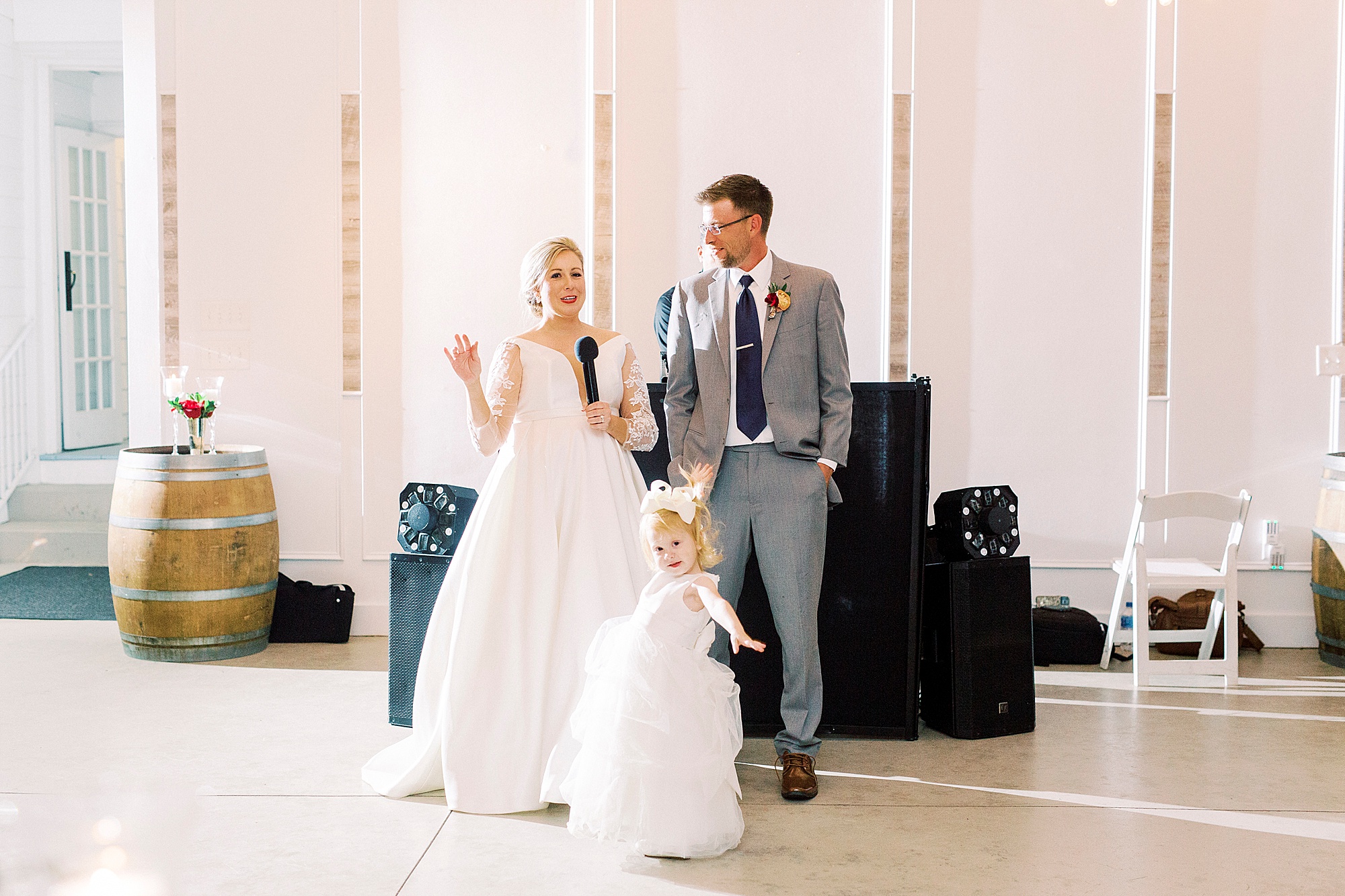 newlyweds thank guests with daughter during wedding reception