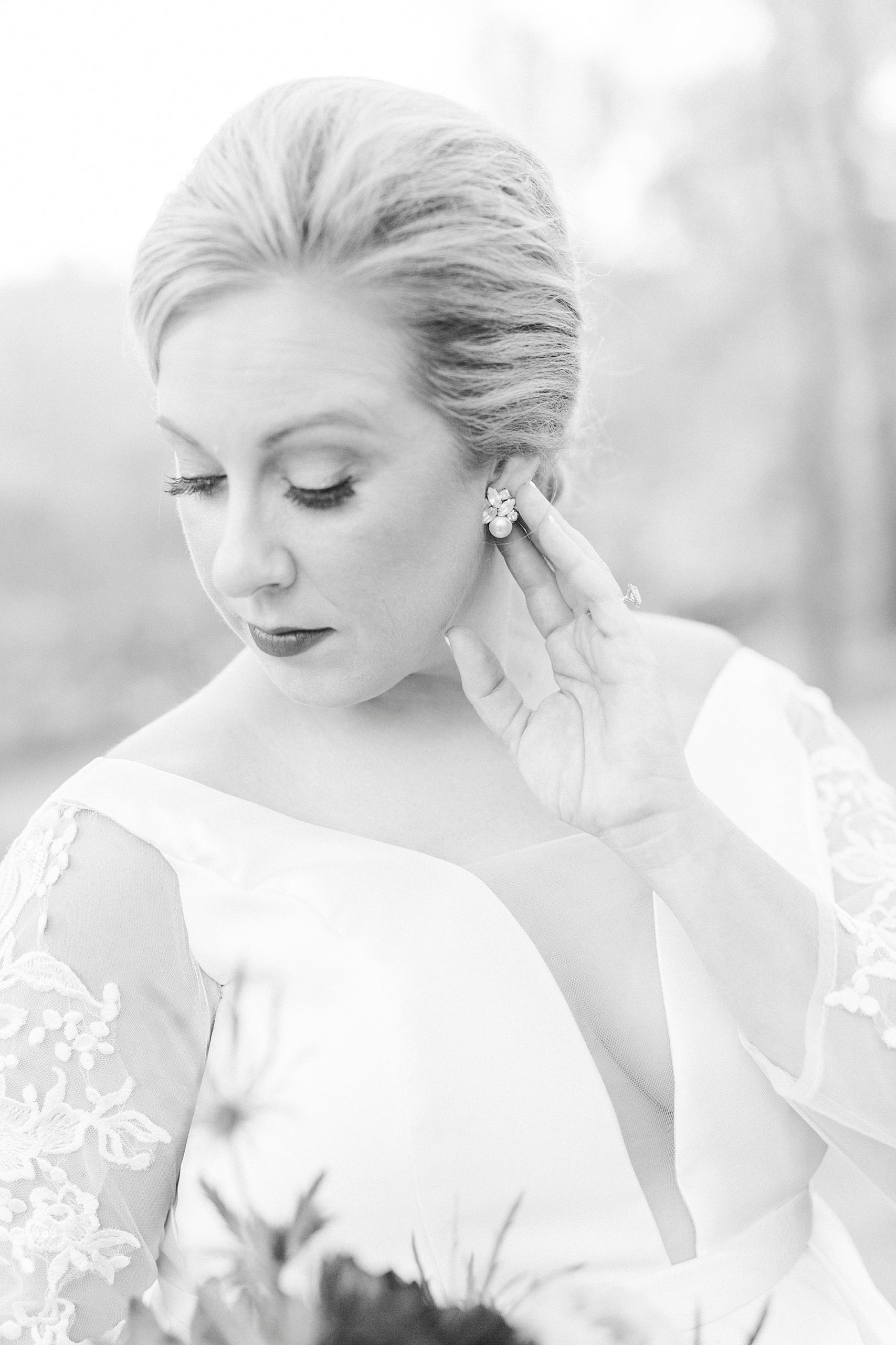 bride holds earring during bridal portraits at Vesuvius Vineyards