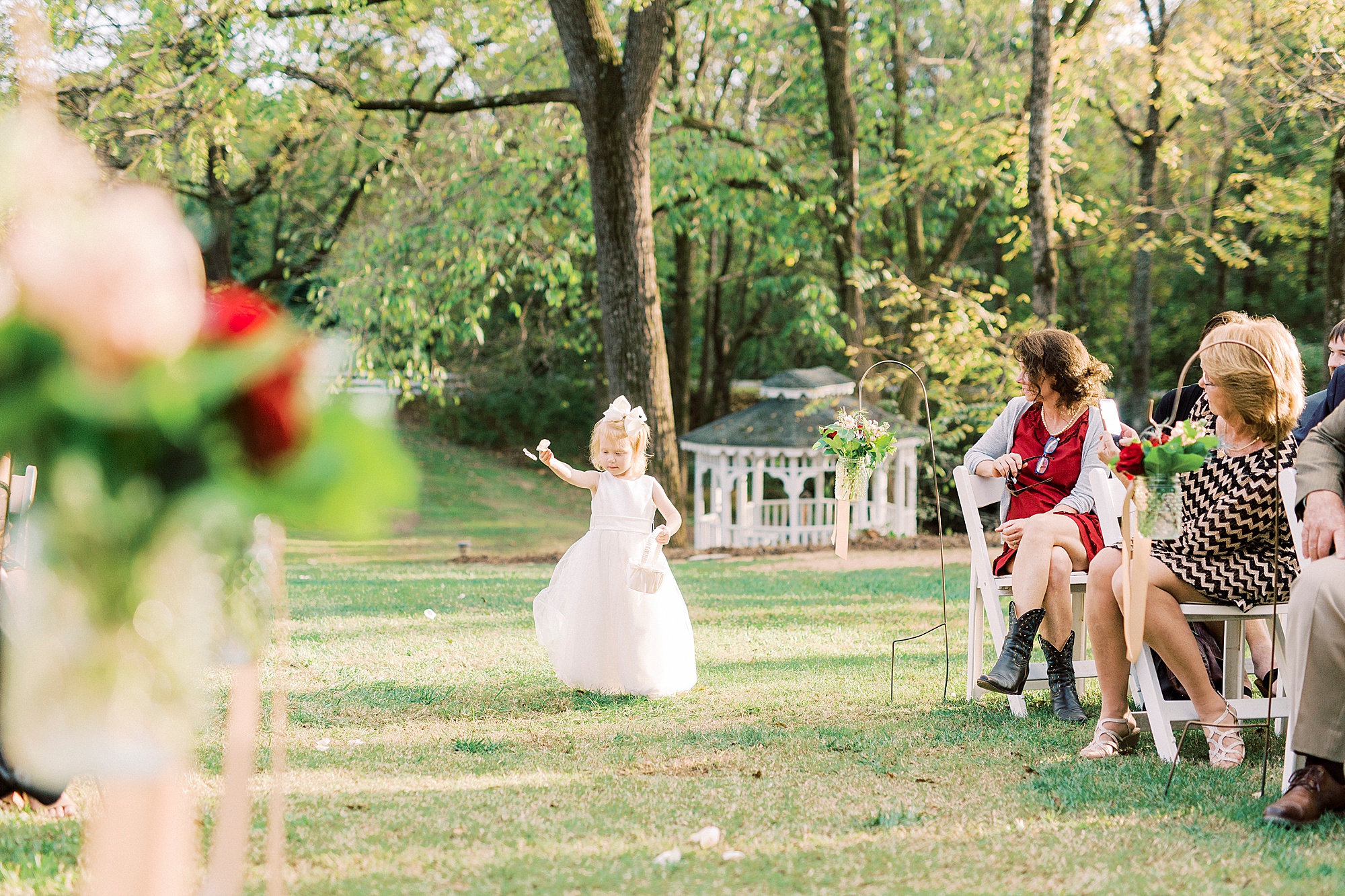 toddler maid of honor walks down aisle for Vesuvius Vineyards wedding ceremony