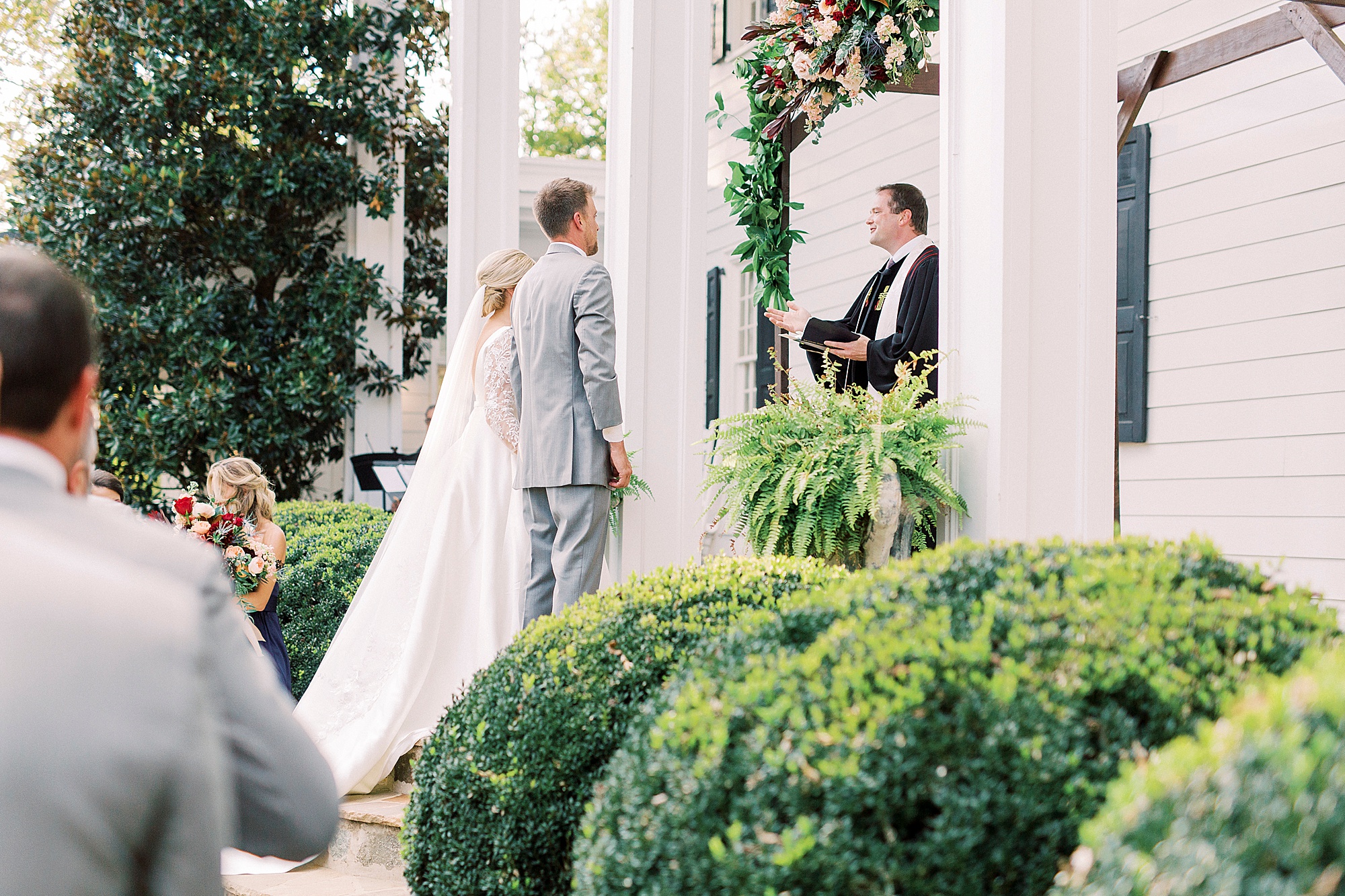 newlyweds stand together during NC wedding ceremony at vineyard
