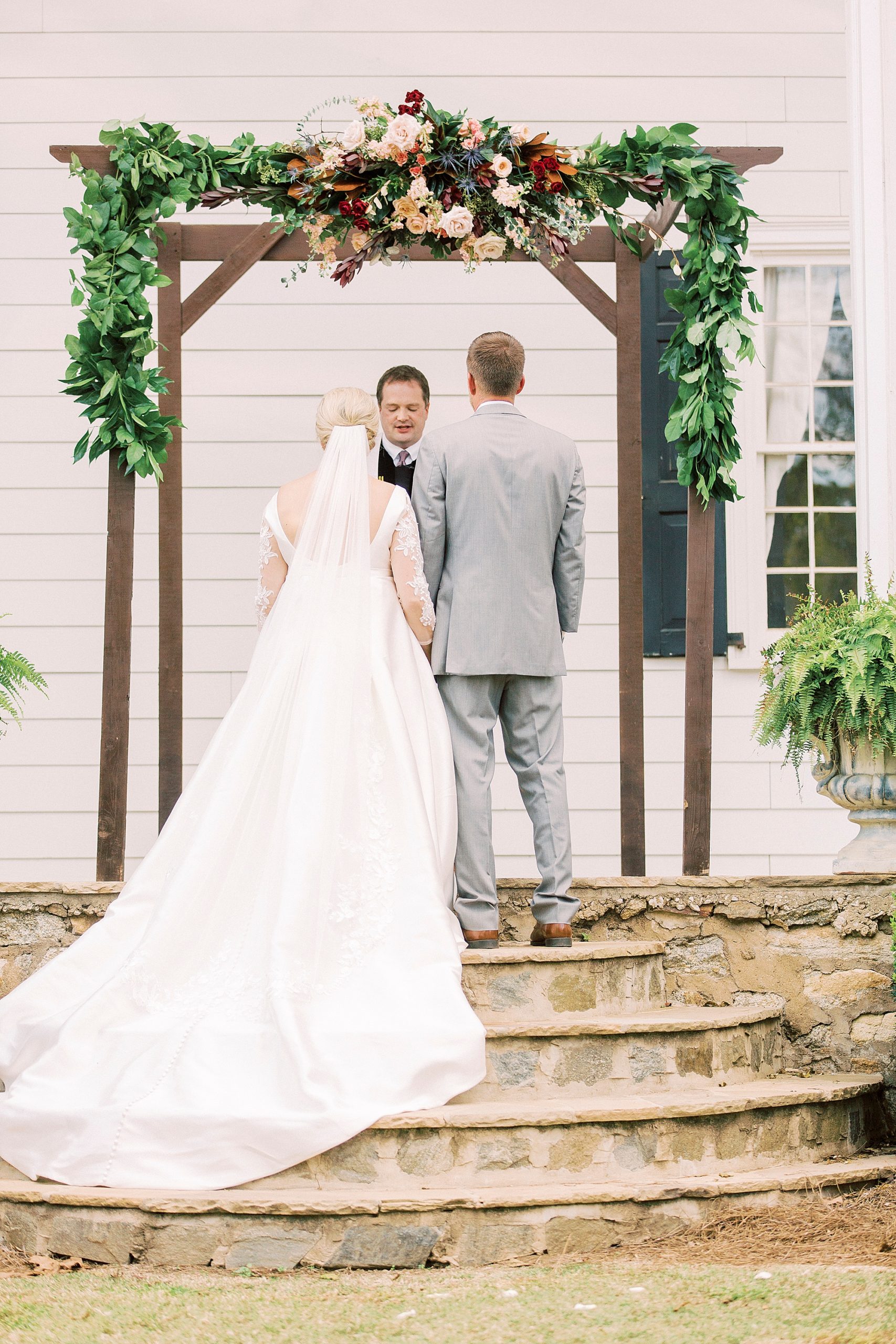bride and groom listen during NC wedding ceremony at vineyard
