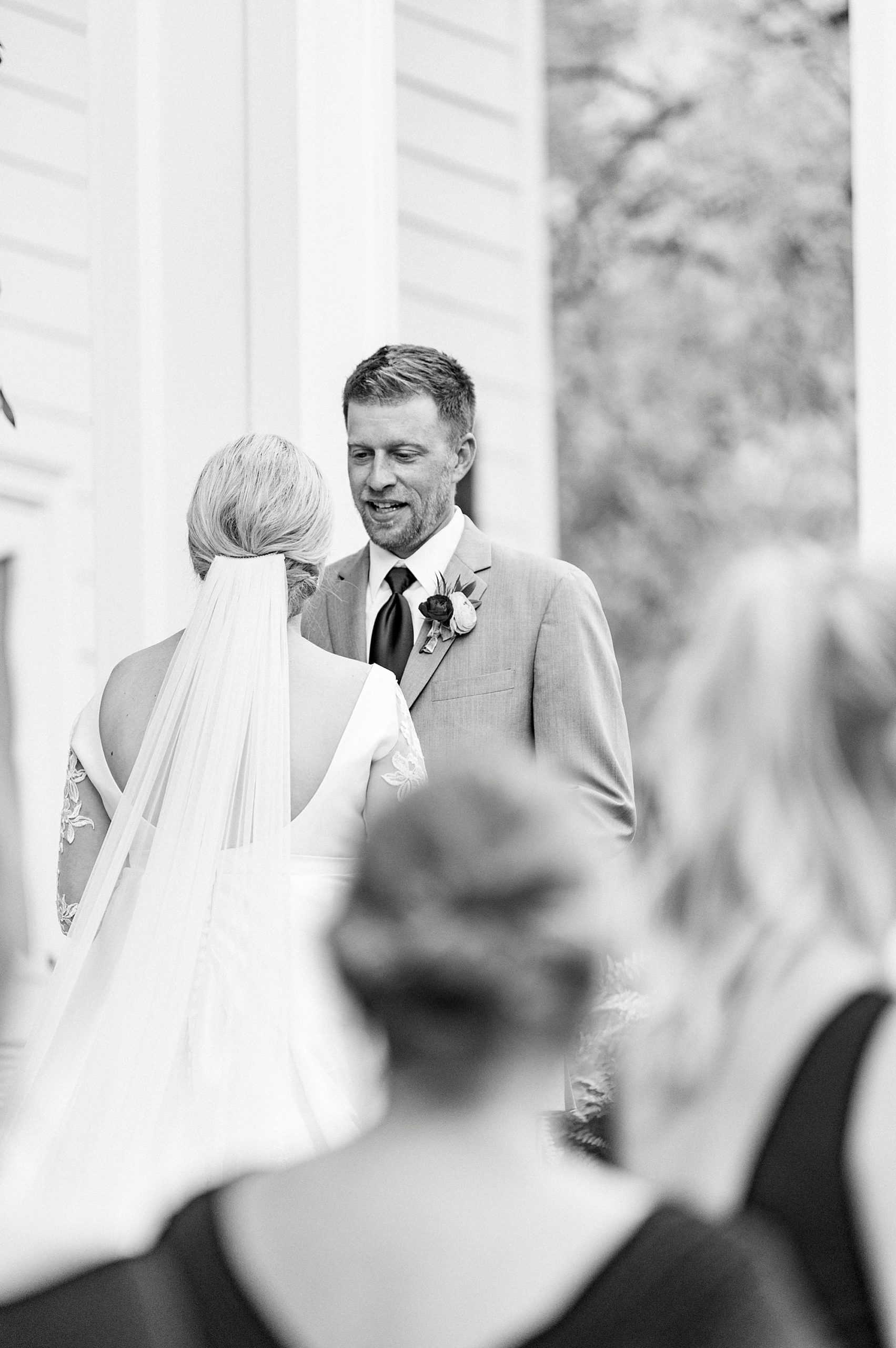 groom looks at bride during NC wedding ceremony at vineyard