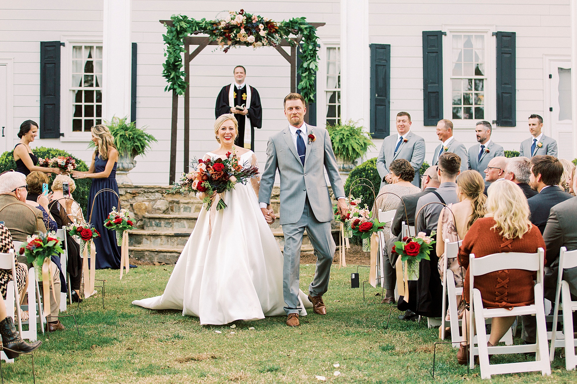 newlyweds walk up aisle during NC wedding ceremony at vineyard