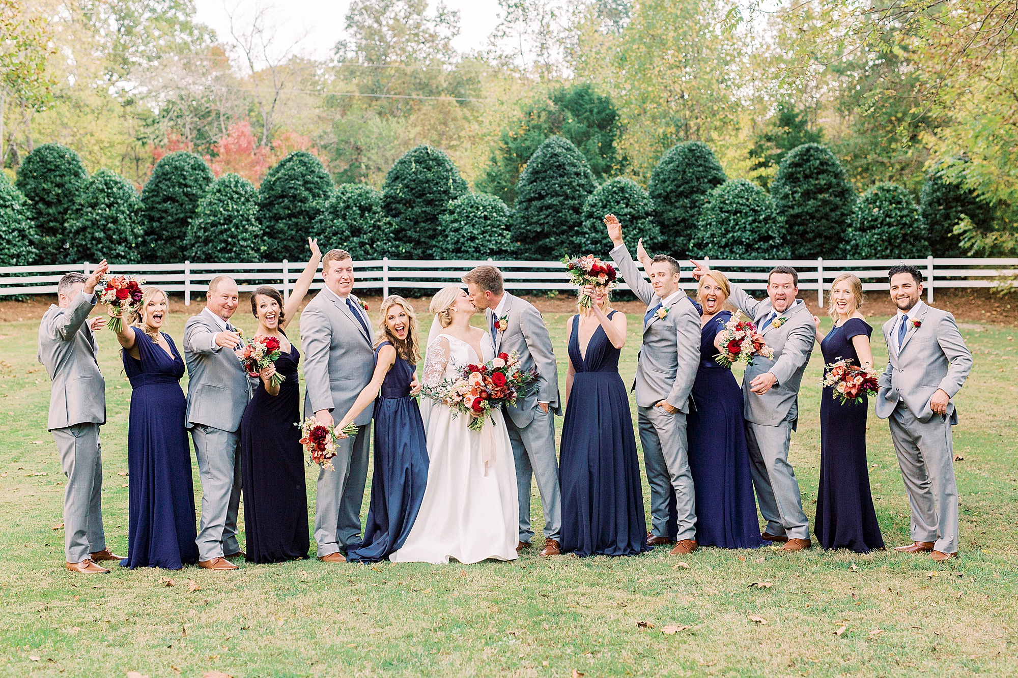 bride and groom kiss while wedding party at Vesuvius Vineyards