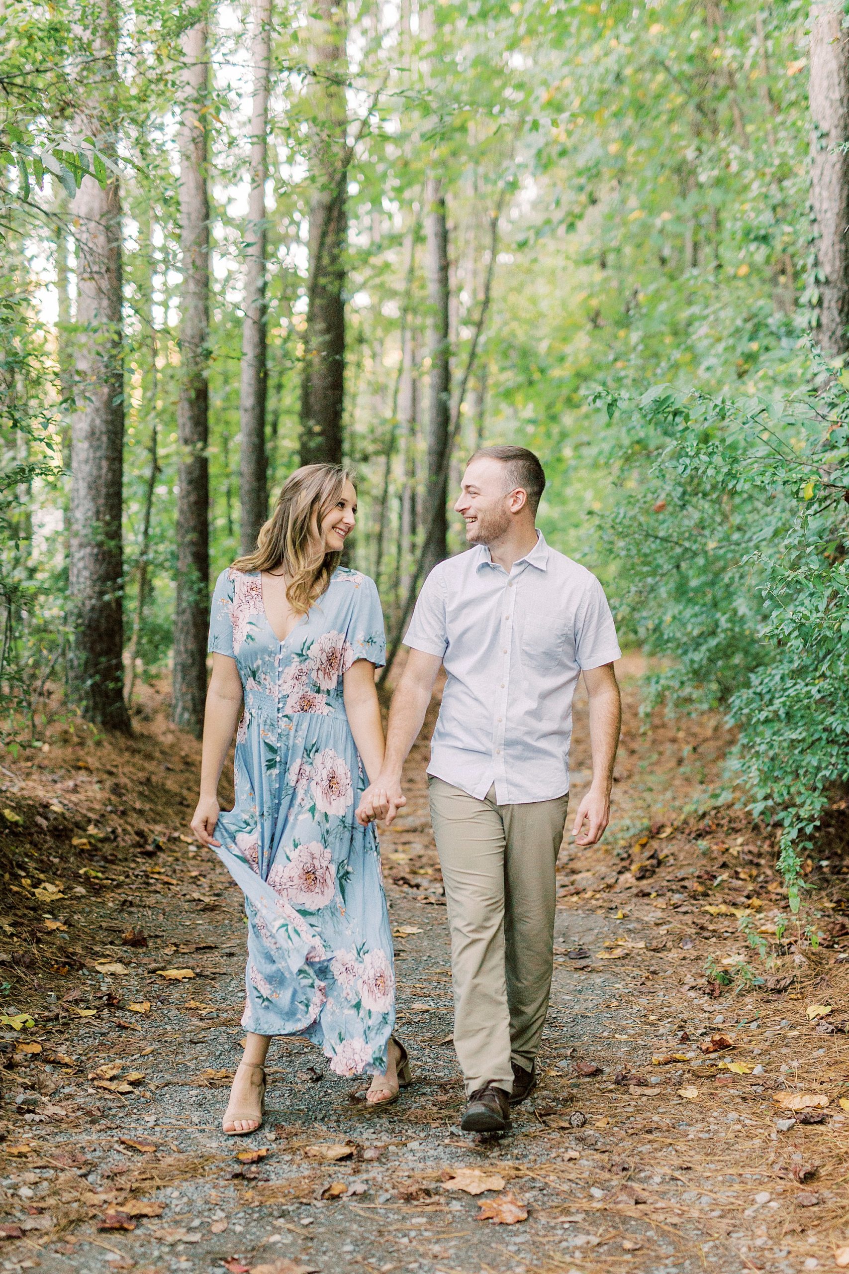 bride and groom walk through woods during Whitewater Center engagement session