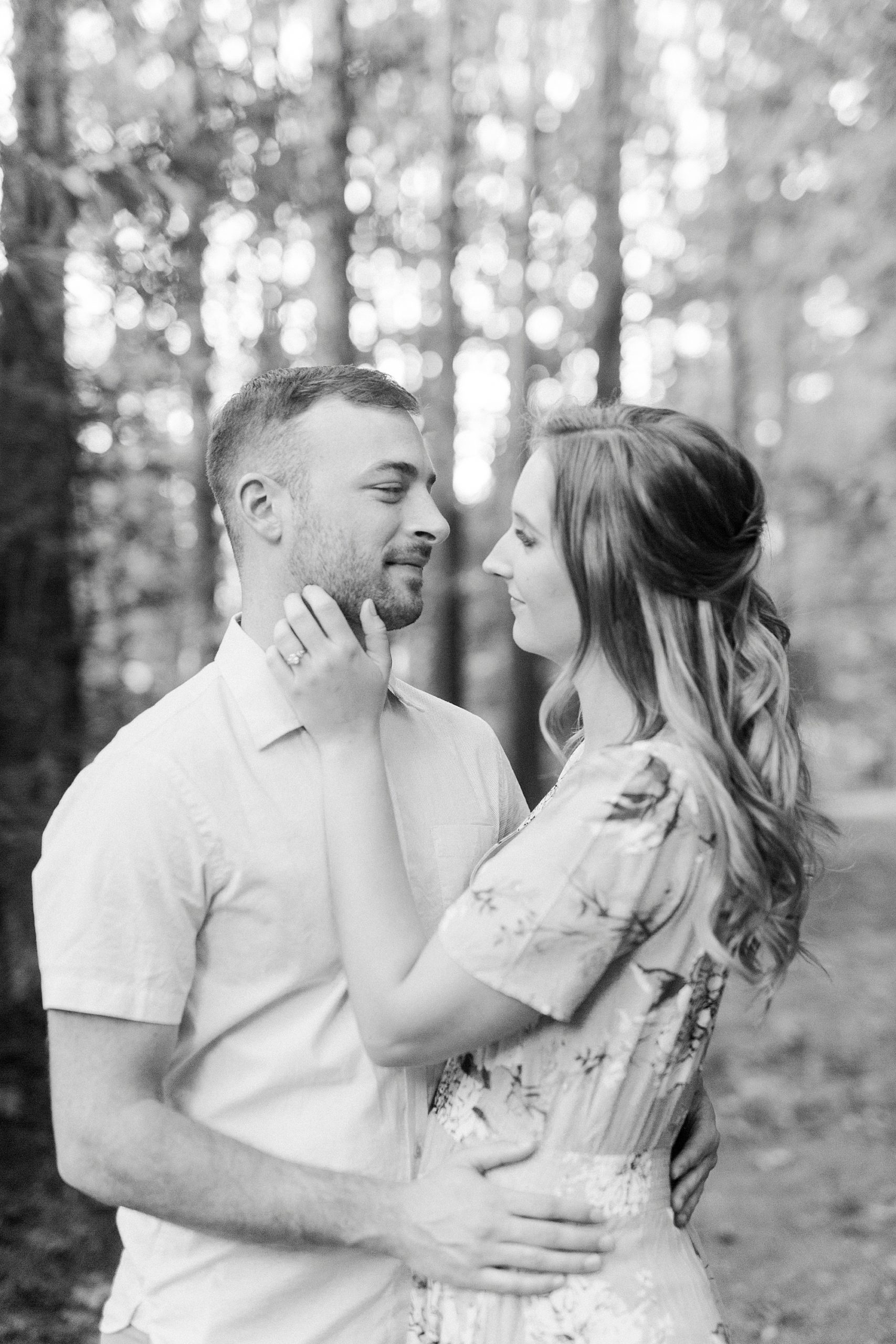 bride holds groom's chin during engagement session at Whitewater Center