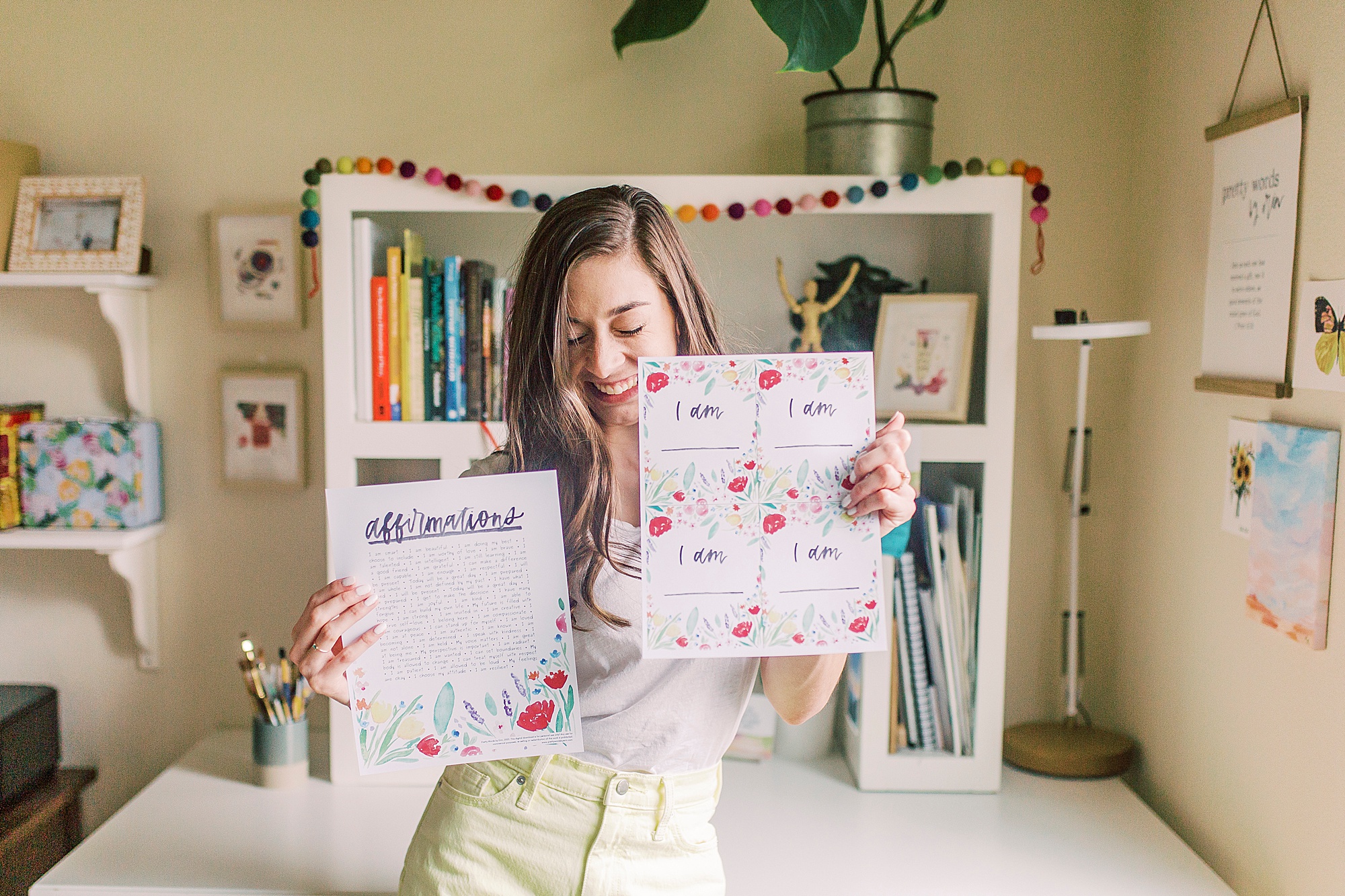 woman holds watercolor art pieces during Charlotte branding session