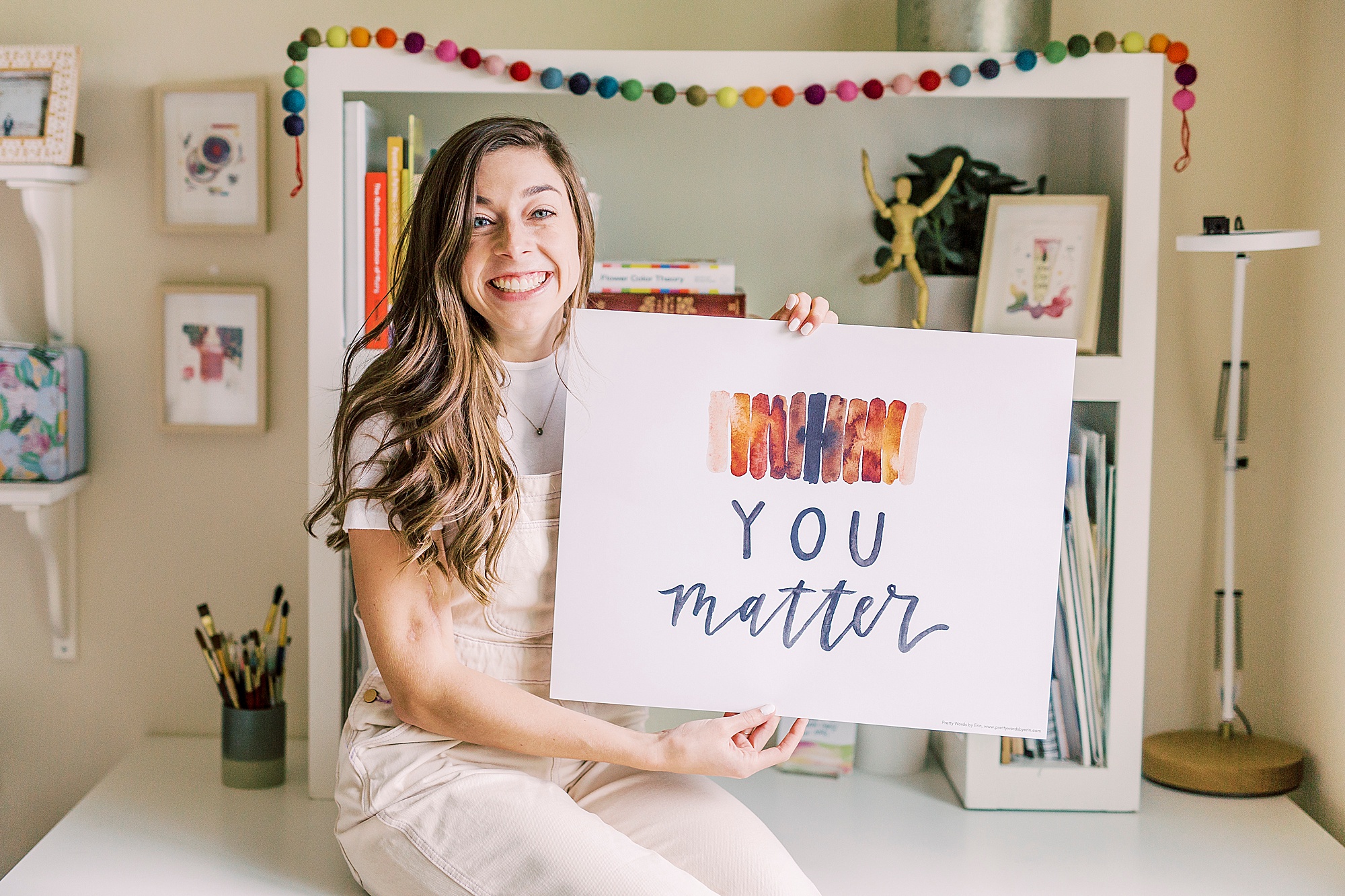 artist holds sign saying "you matter" during Charlotte branding session