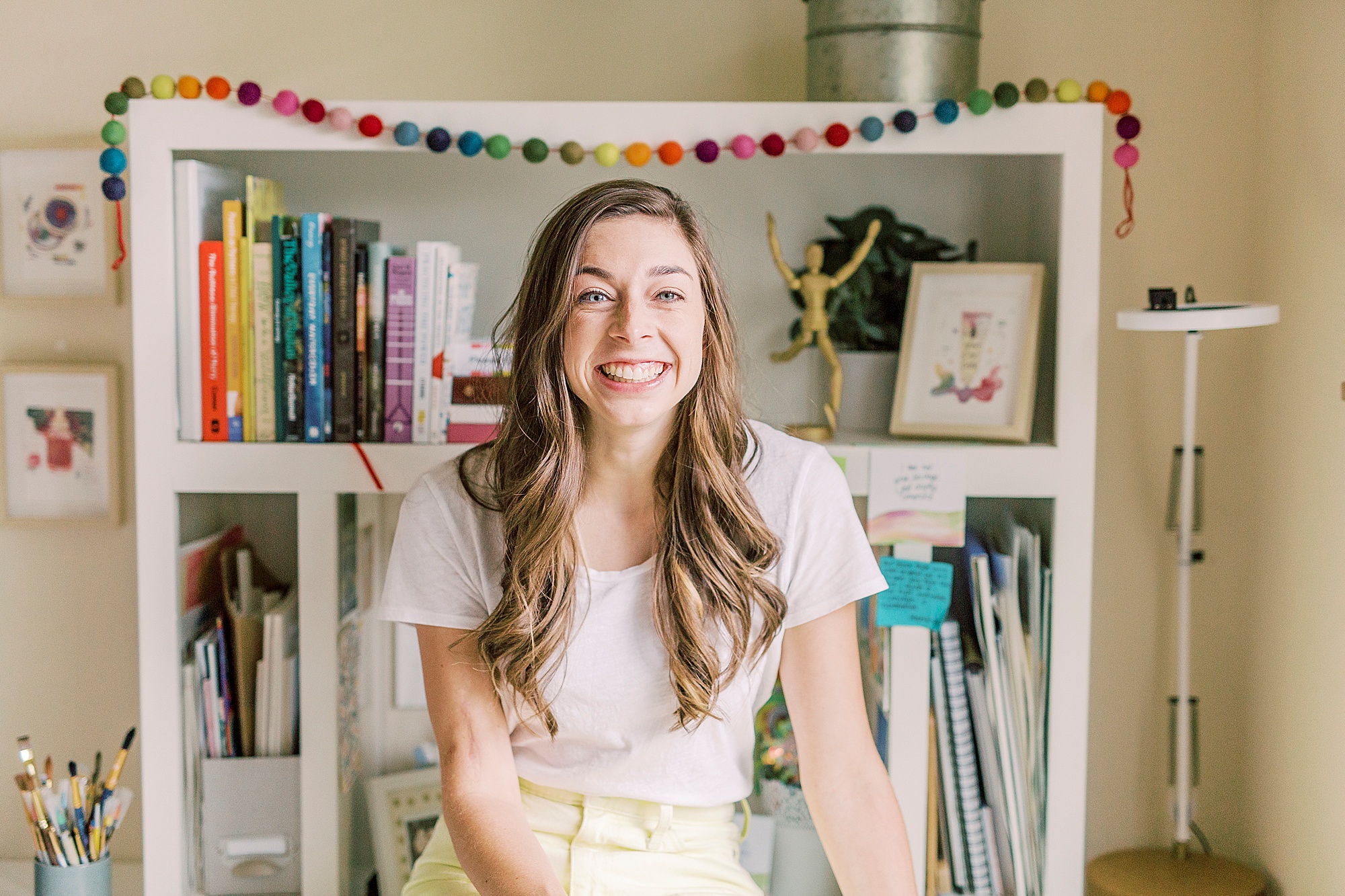 woman sits on desk during branding photos at home in Charlotte NC