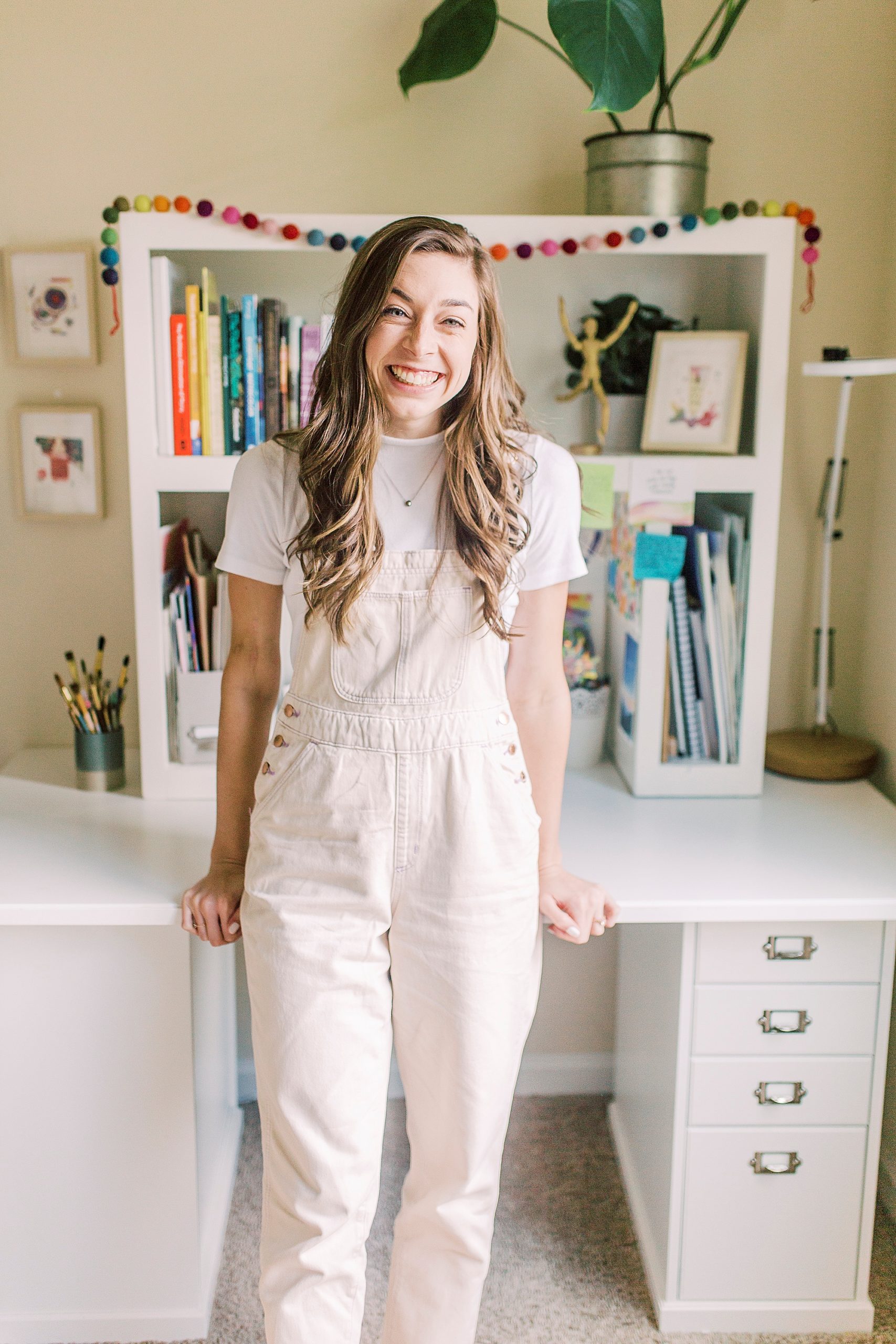 woman leans against desk during Charlotte branding session at home
