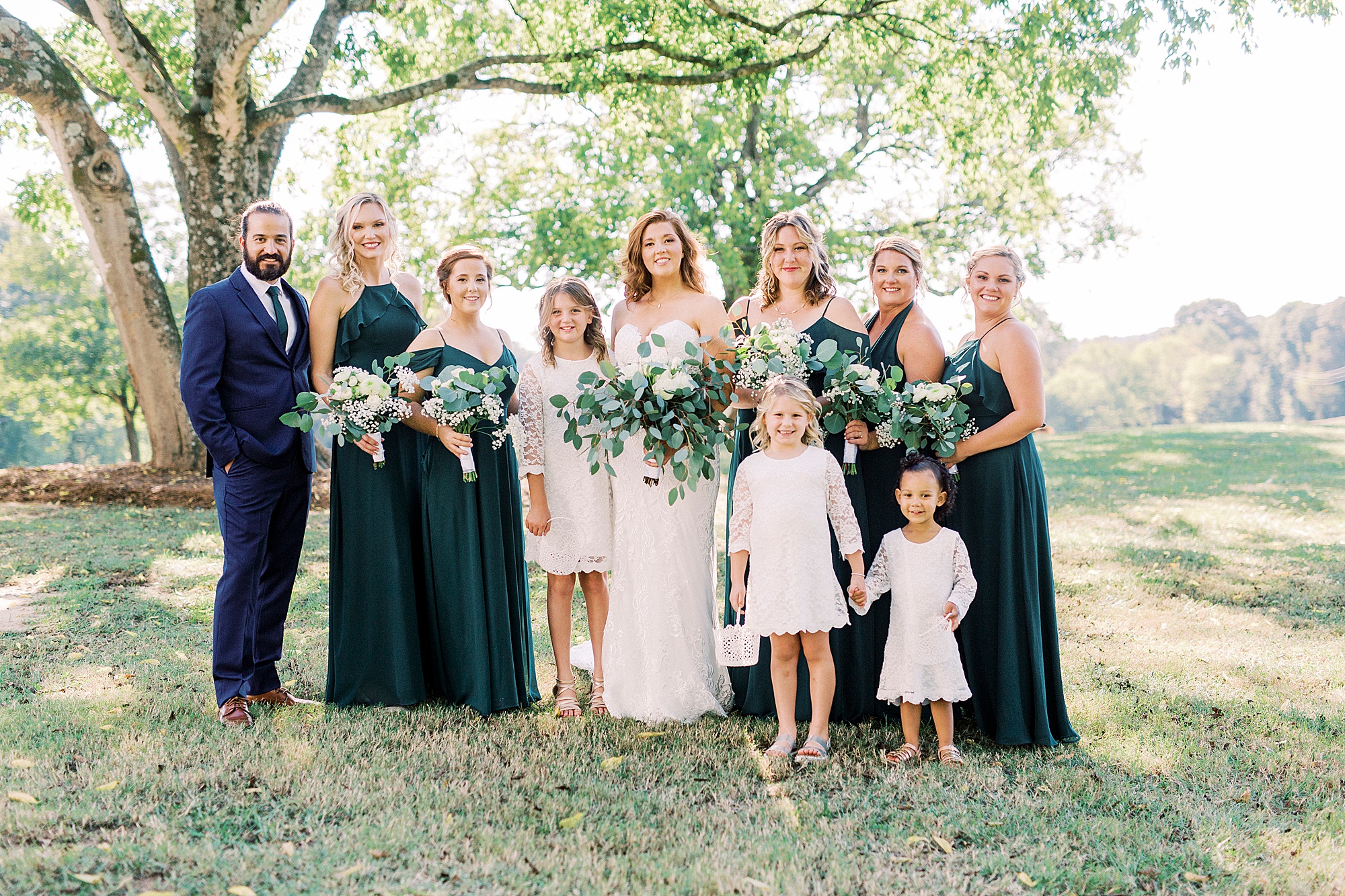 bride poses with bridesmaids and flower girls