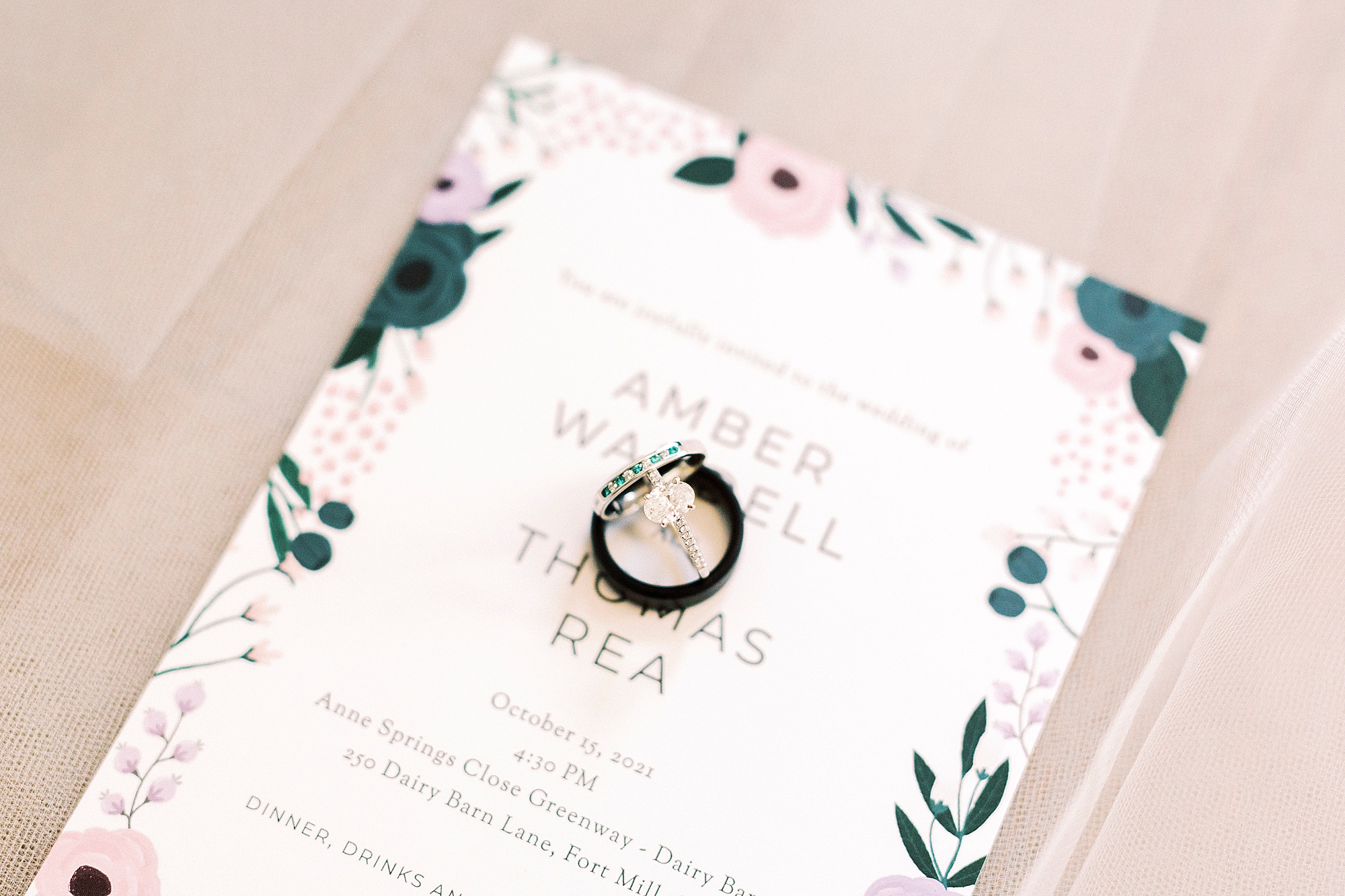 wedding rings rest on invitation for fall wedding
