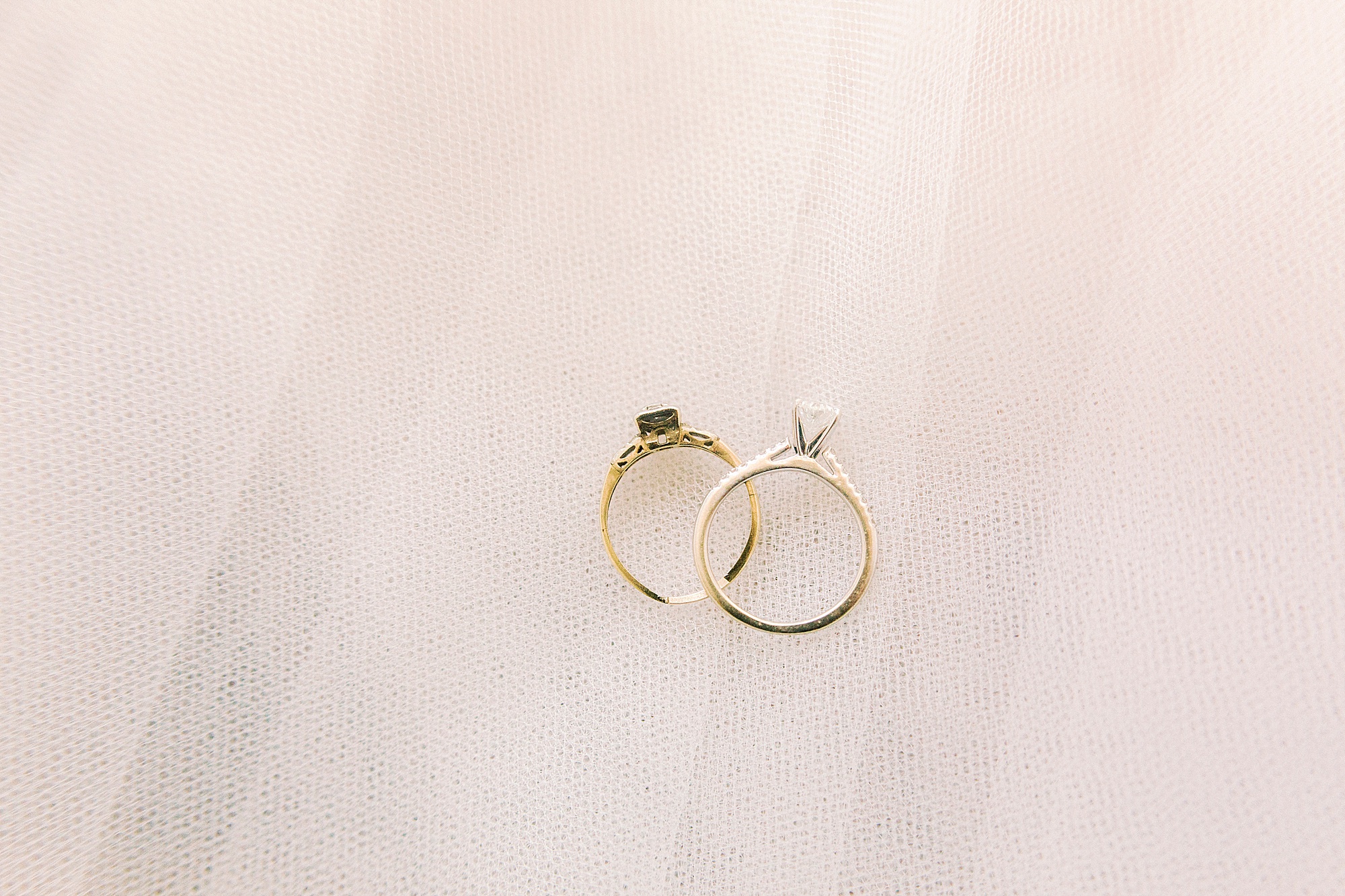gold wedding bands rest on veil