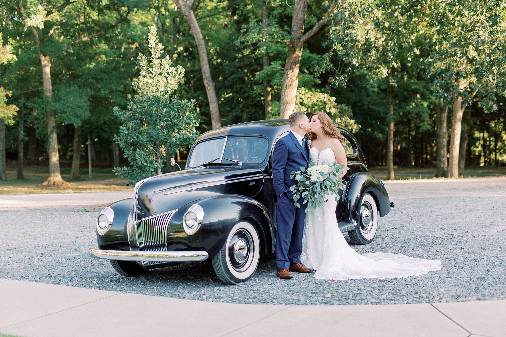 bride and groom kiss by classic car in South Carolina