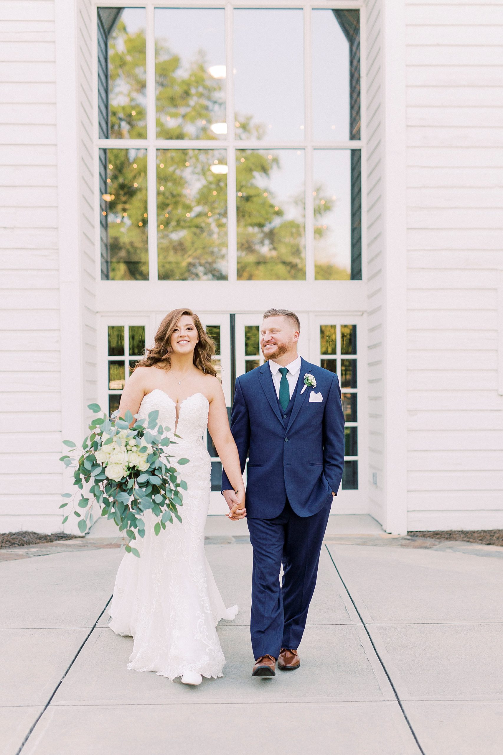 newlyweds hold hands walking outside of The Dairy Barn