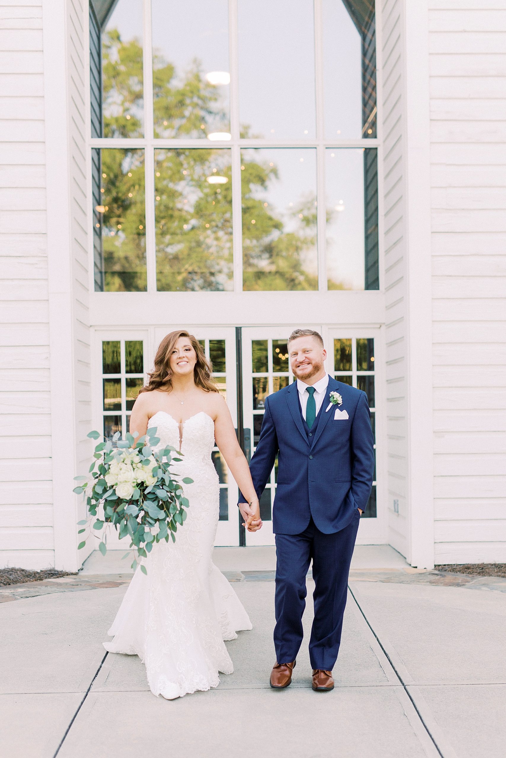 newlyweds hold hands outside The Dairy Barn