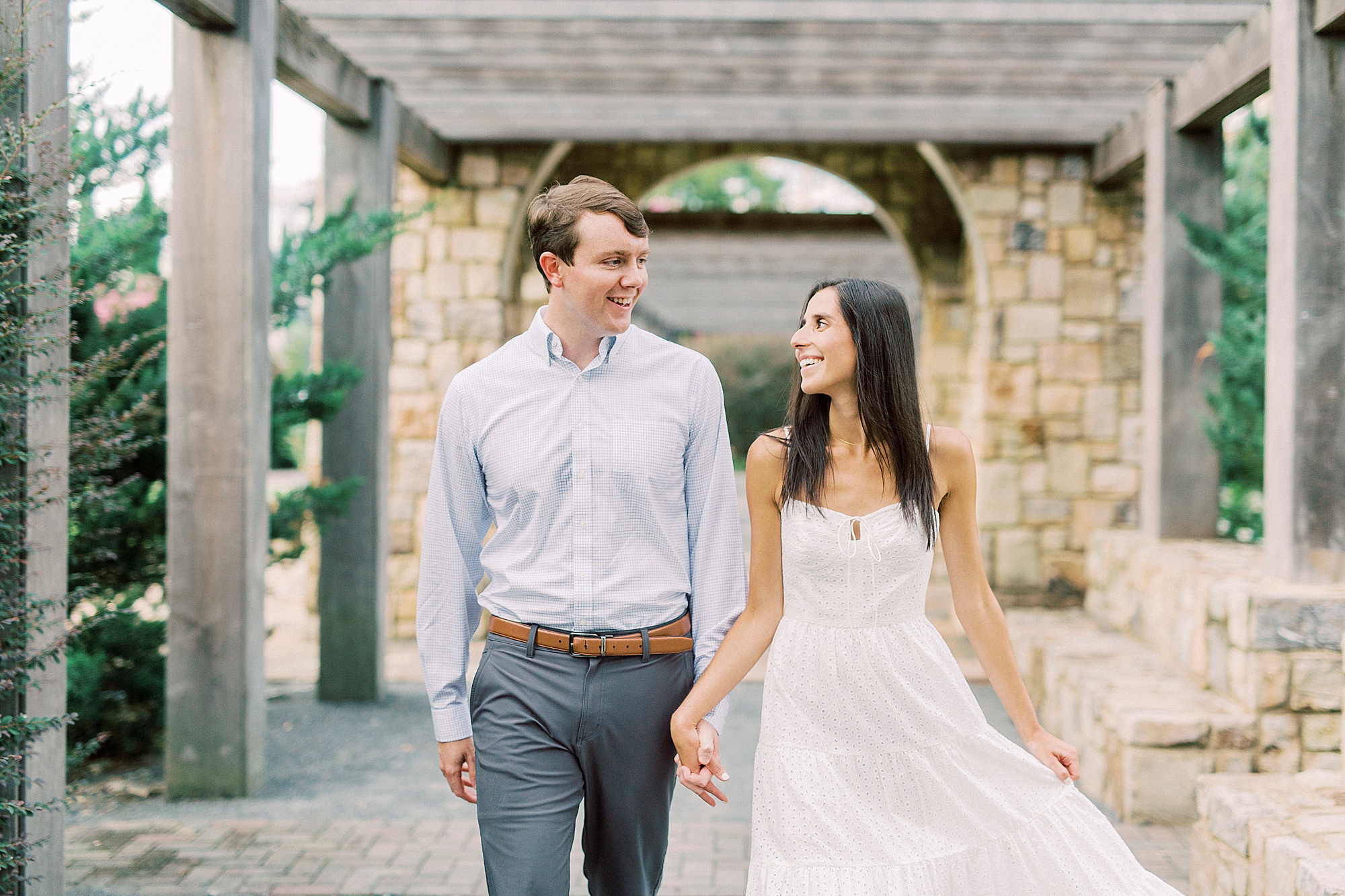 couple walks through stone arbor at Midtown Park
