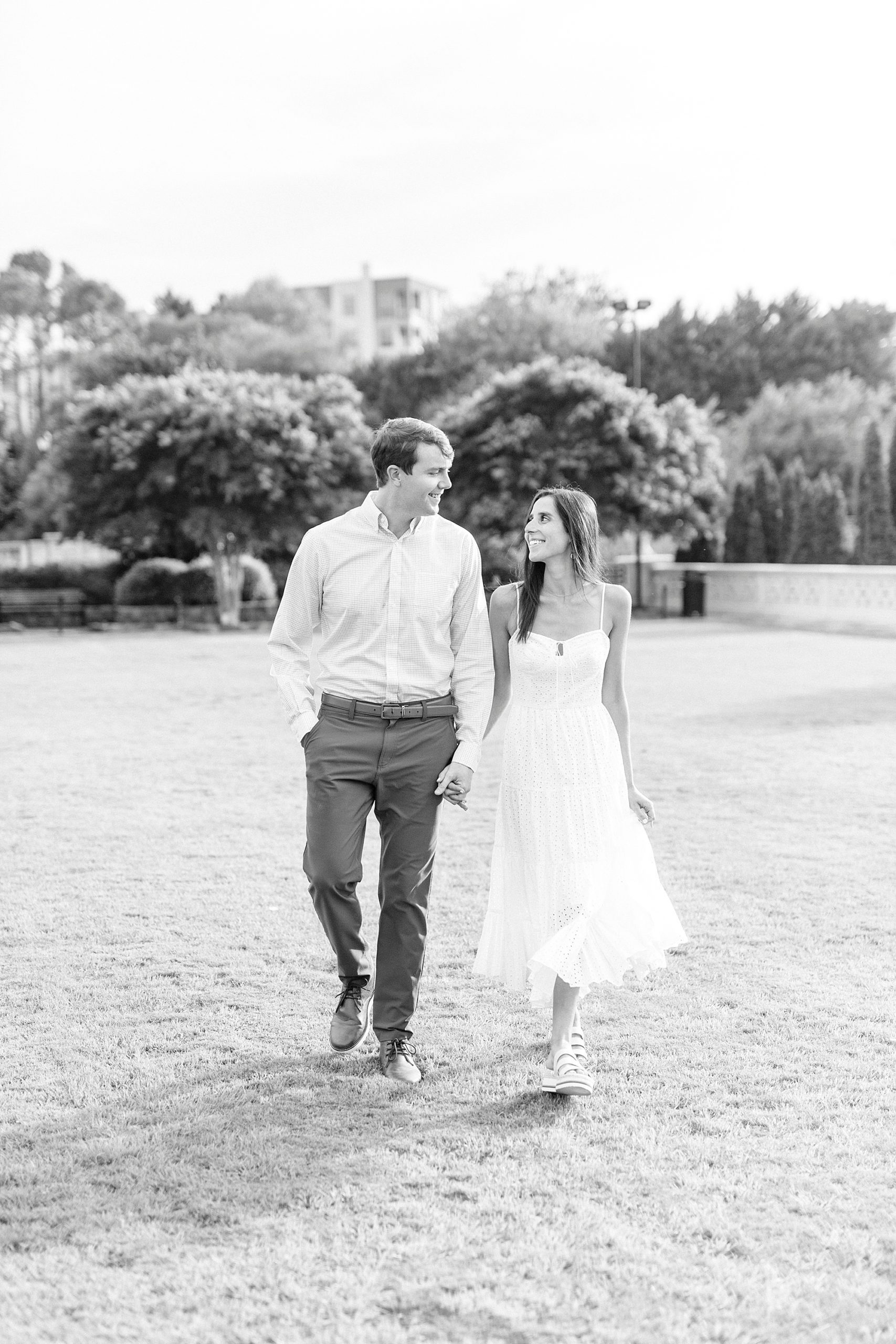 couple holds hands walking through park in Charlotte NC
